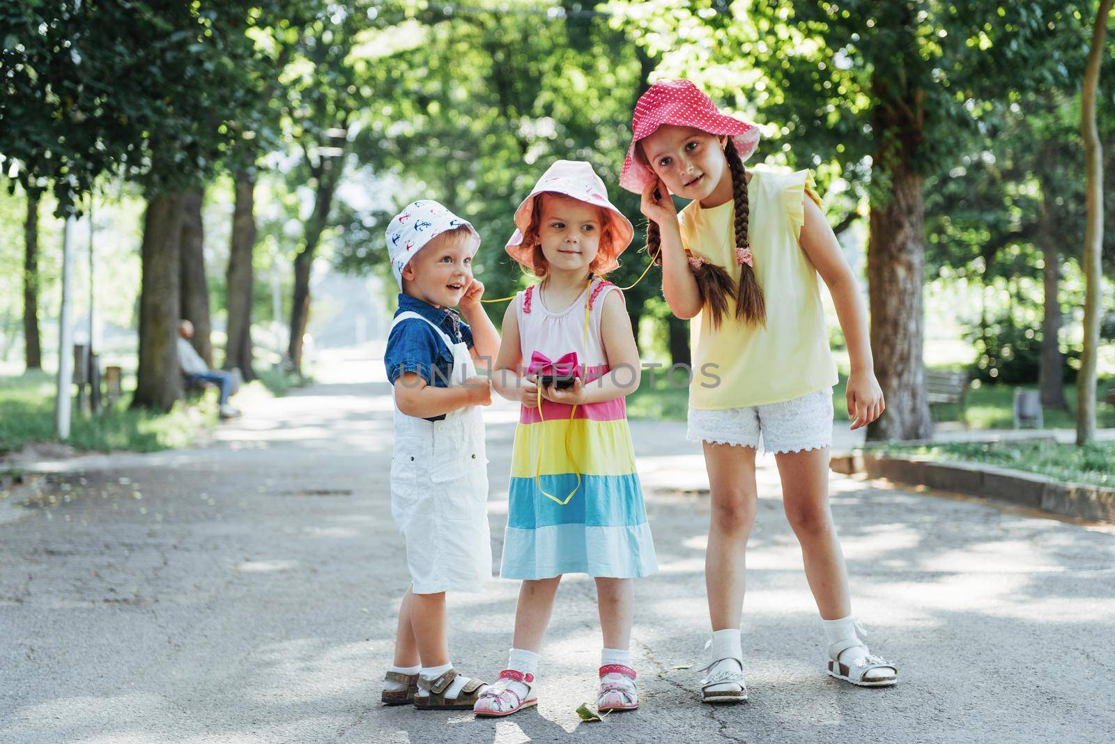 Cute girl and boy listening to music through headphones on the street.