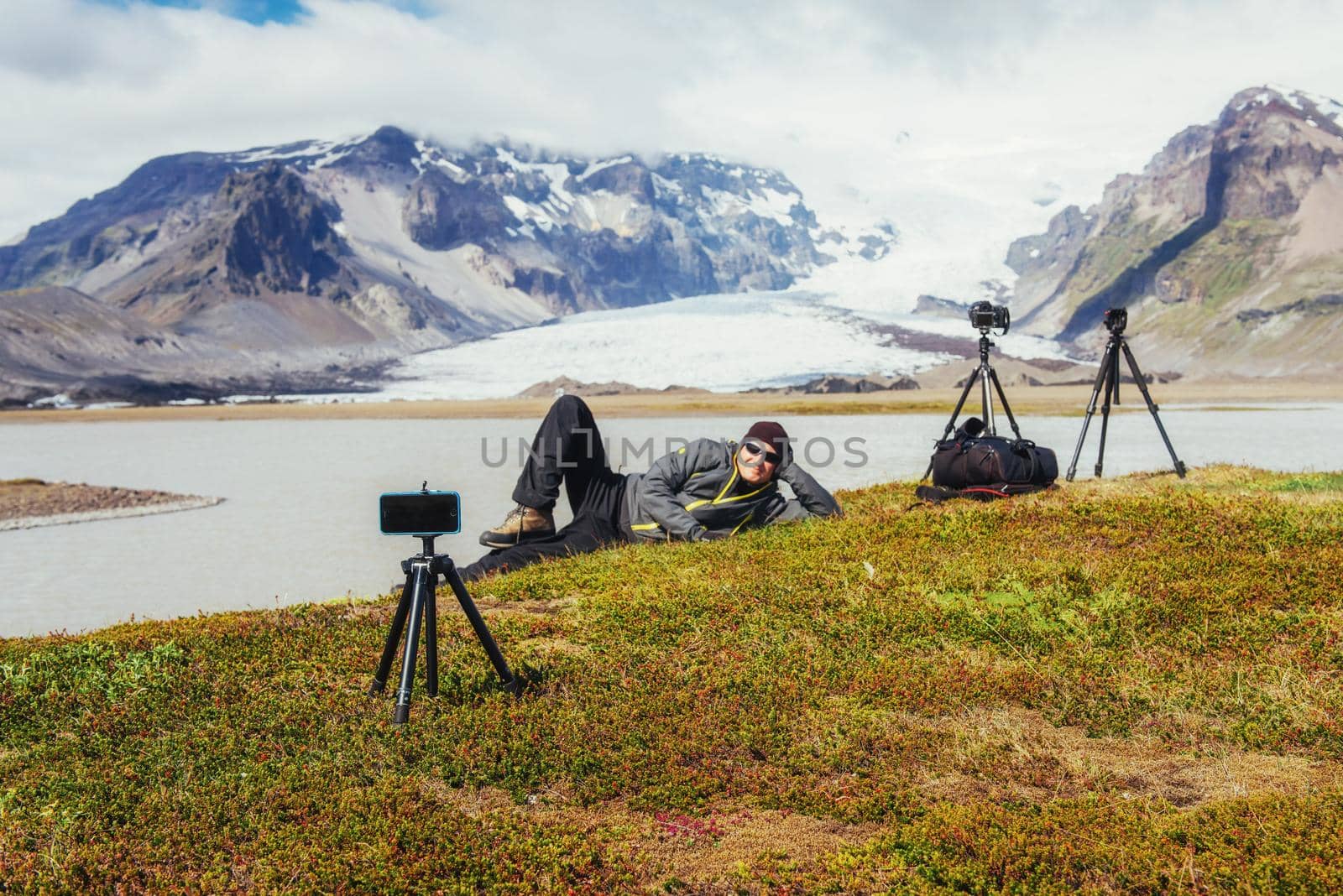 Photographer picturesque location in Iceland. Admiring the beauty of the mountains. Fantastic spring landscape.