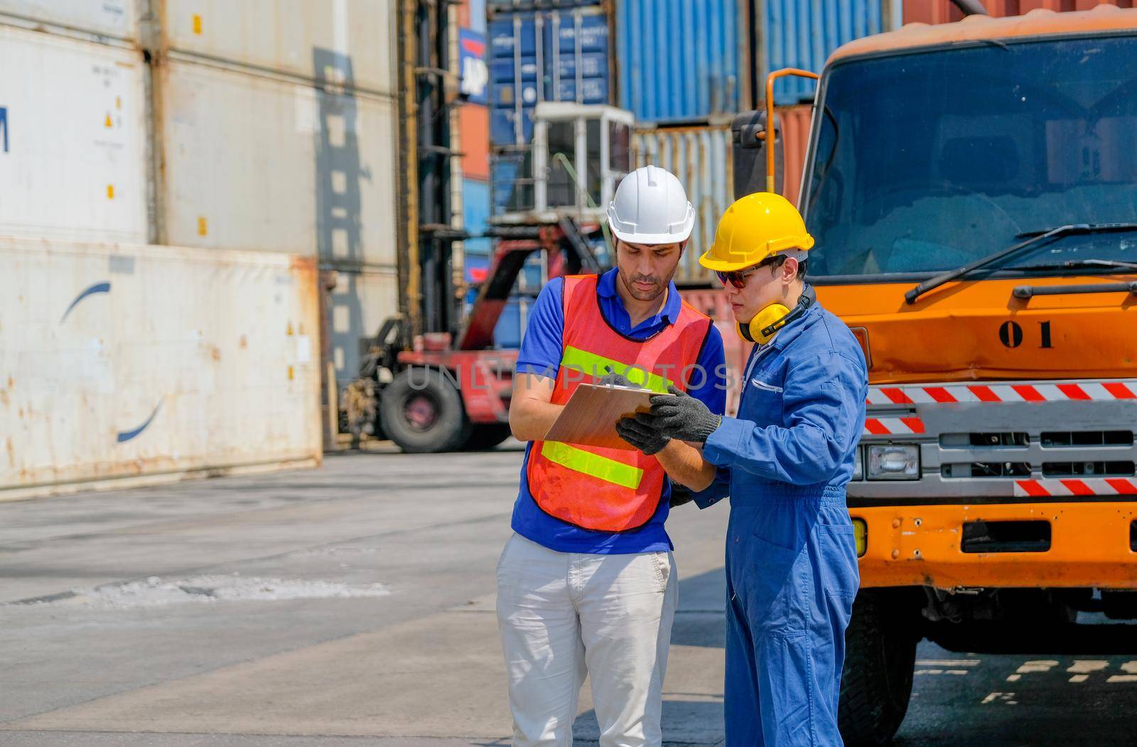 Technician and engineer work together for checking quality and product in cargo container shipping area.