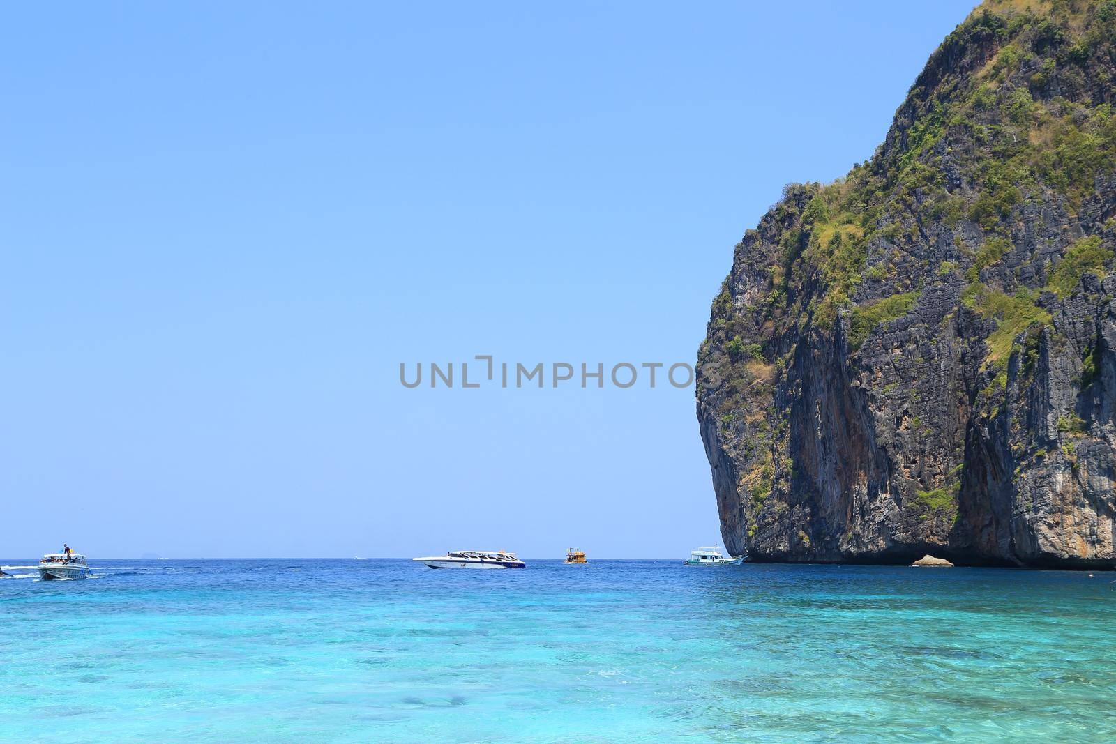 Maya Bay lagoon with Motor boat on turquoise water, Phi Phi island, Thailand