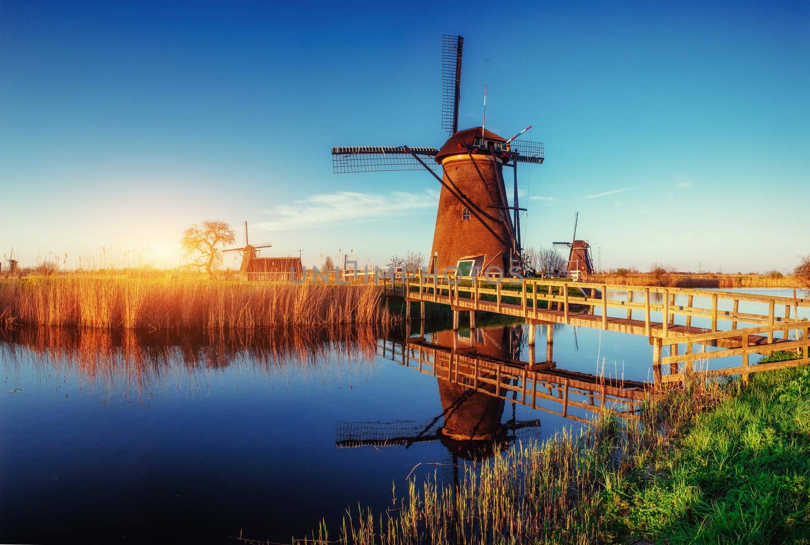The road leading to the Dutch windmills from the canal in Rotterdam. Holland. Netherlands