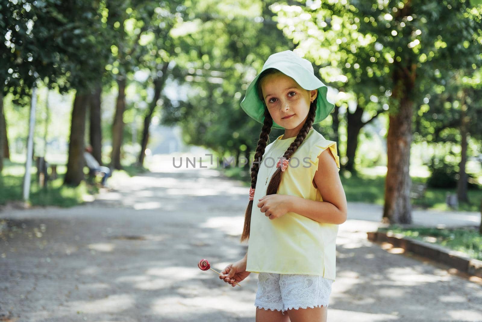 Funny child with candy lollipop, happy little girl eating big sugar lollipop, kid eat sweets.