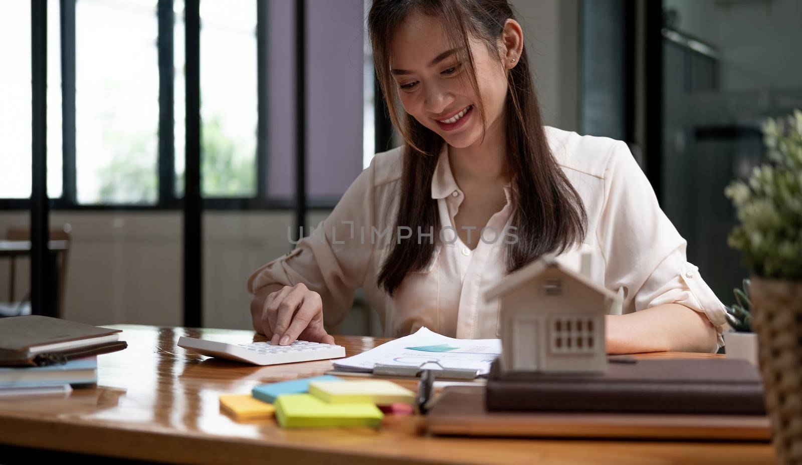 Businesswoman doing finances and calculate about cost to real estate investment and in other, tax system. Business Financing Accounting Banking Concept.