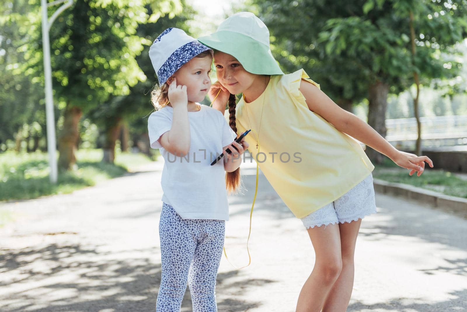 Happy girl with headphones to share music from your smartphone on street