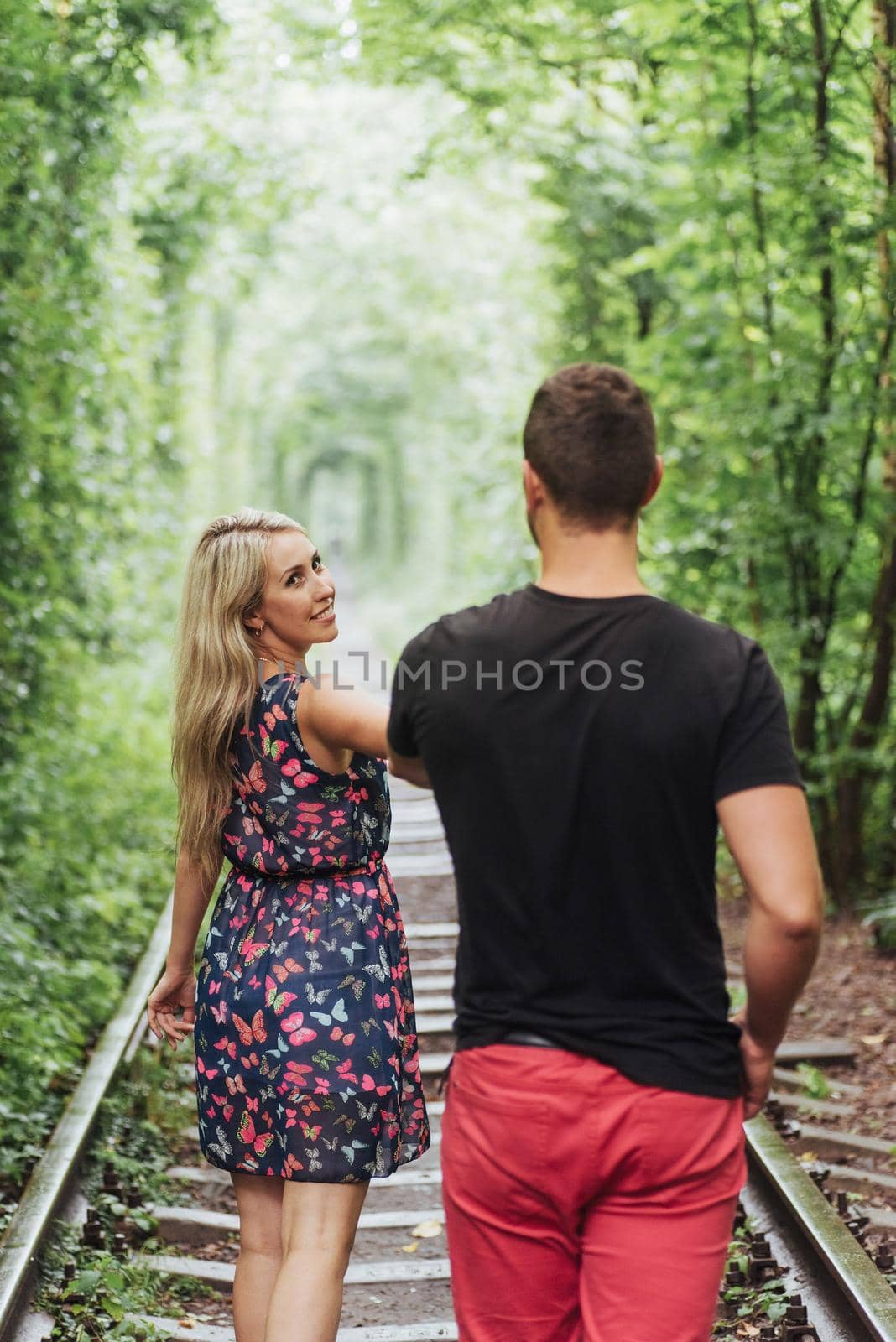 Loving couple in love tunnel iron road.