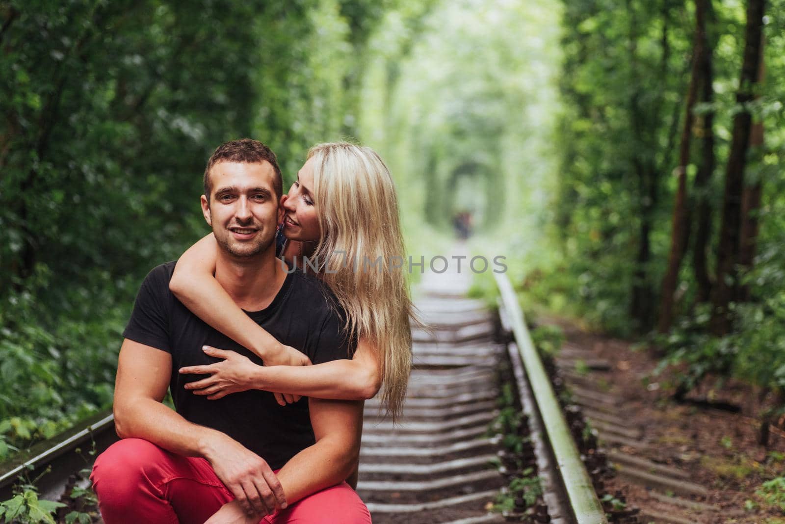 Loving couple in love tunnel iron road.