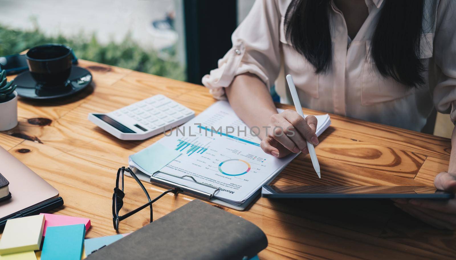 Close up Accounting woman using digital tablet with pen stylus on working space, business financial concept.