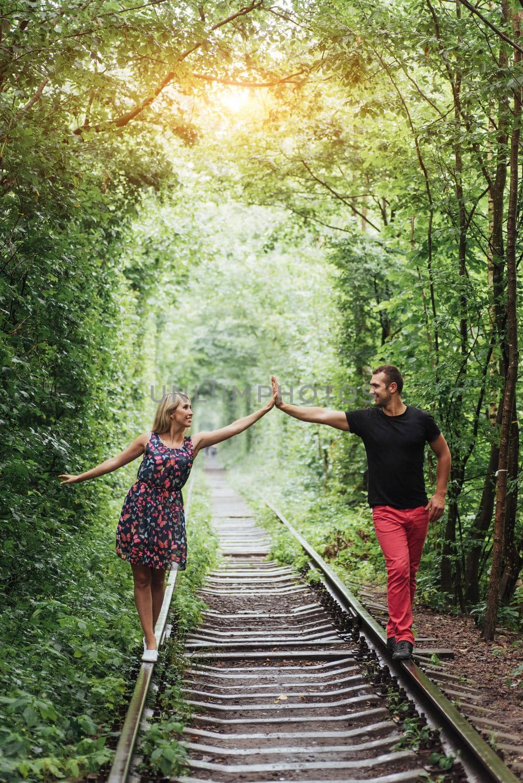 Loving couple in love tunnel iron road.