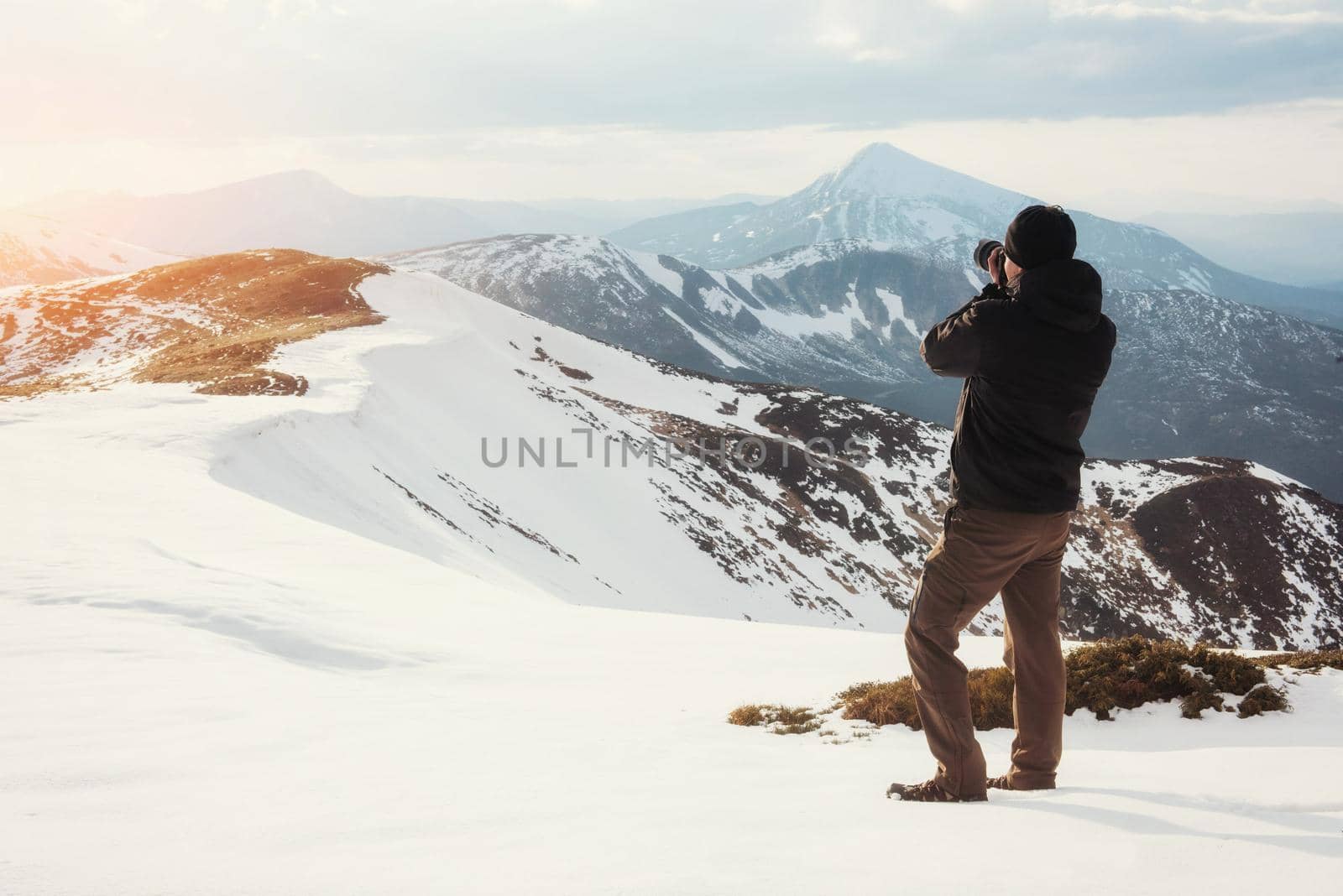 tourist looks at the landscape. Photographer on top of mountain. Spring landscape. Carpathians Ukraine Europe