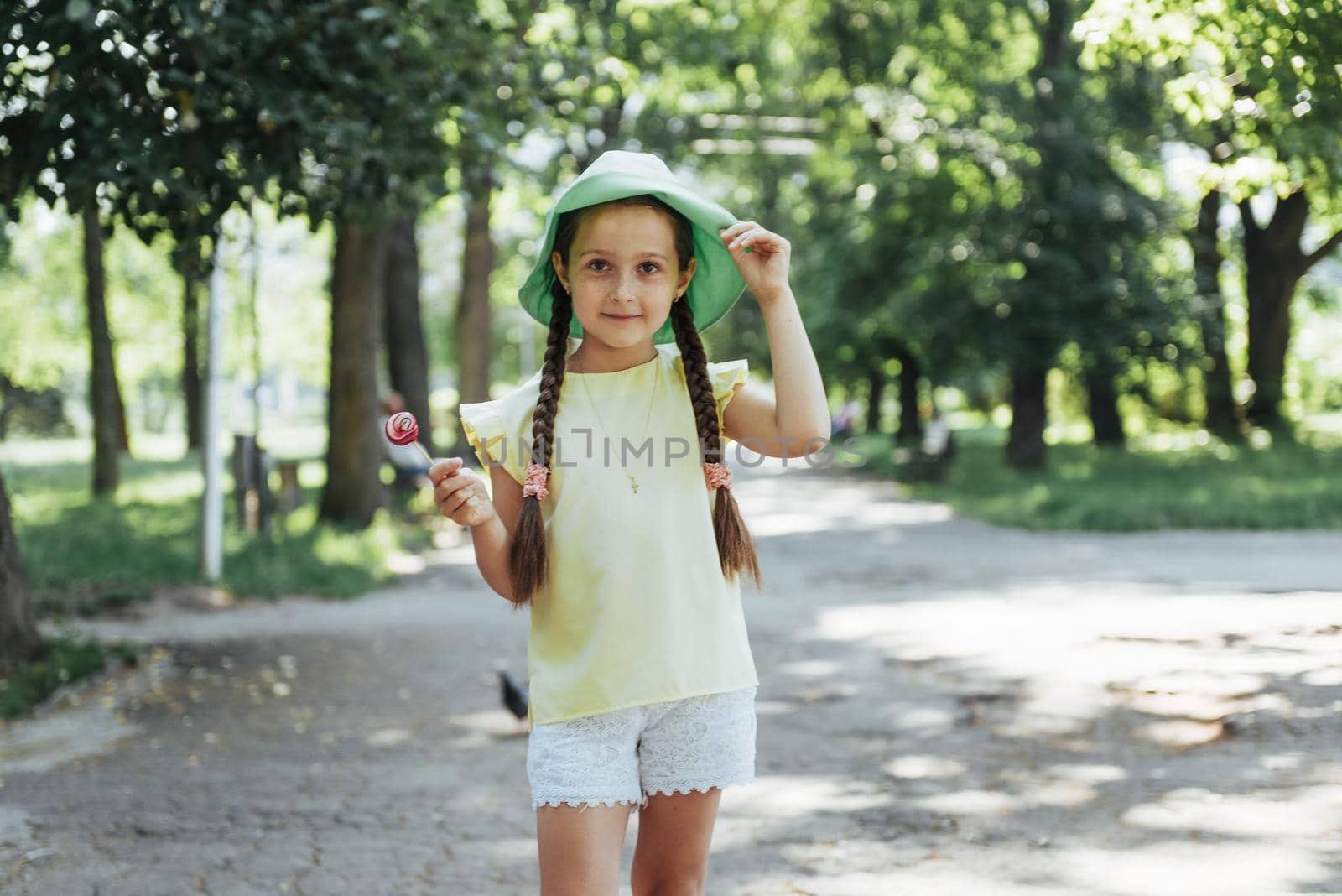 Funny child with candy lollipop, happy little girl eating big sugar lollipop, kid eat sweets.