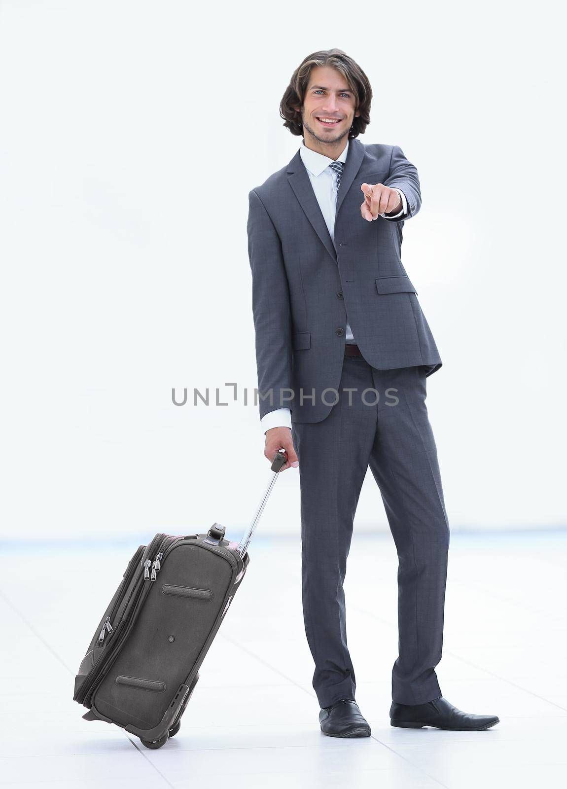 businessman with travel suitcase pointing forward by asdf