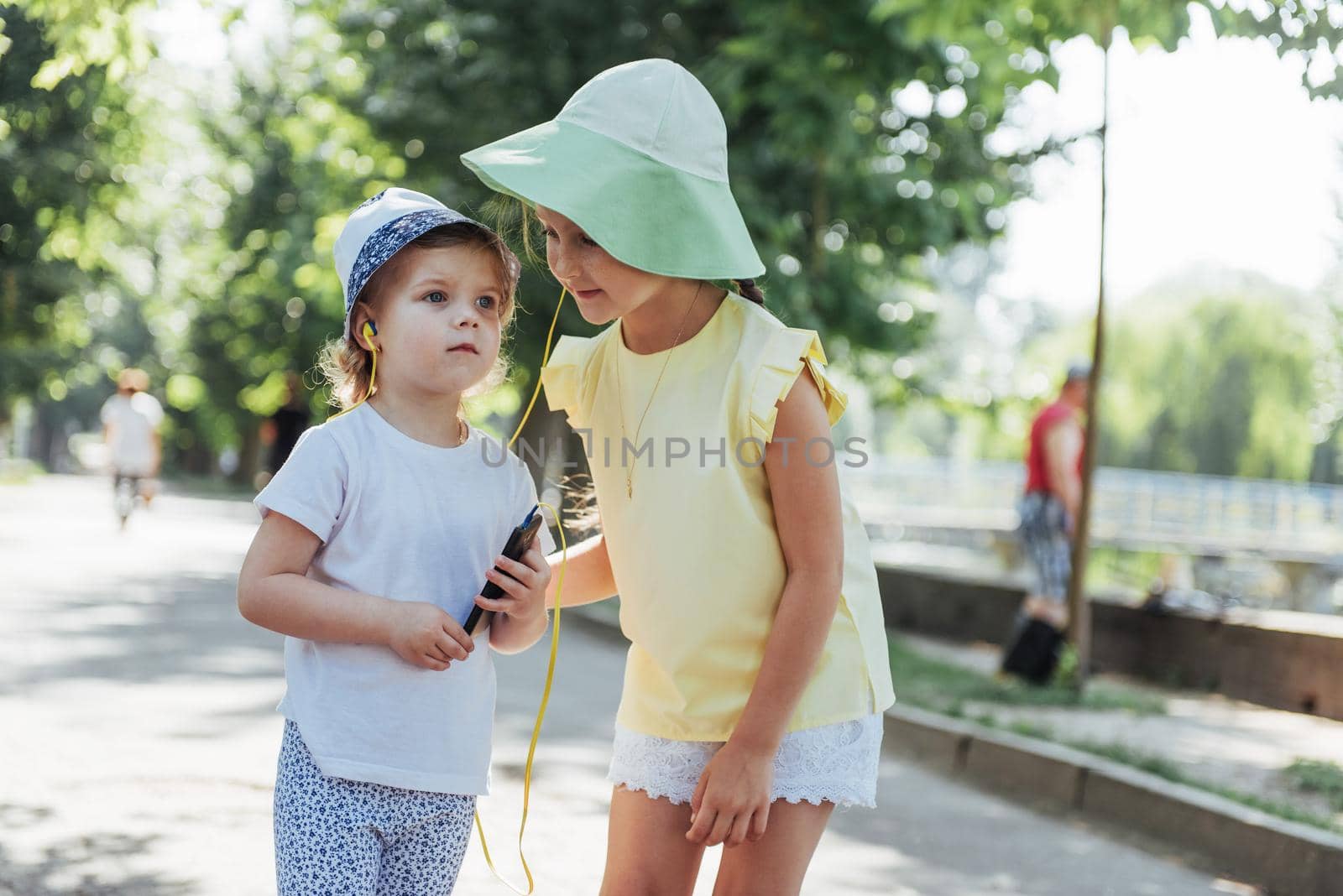 Happy girl with headphones to share music from your smartphone on street