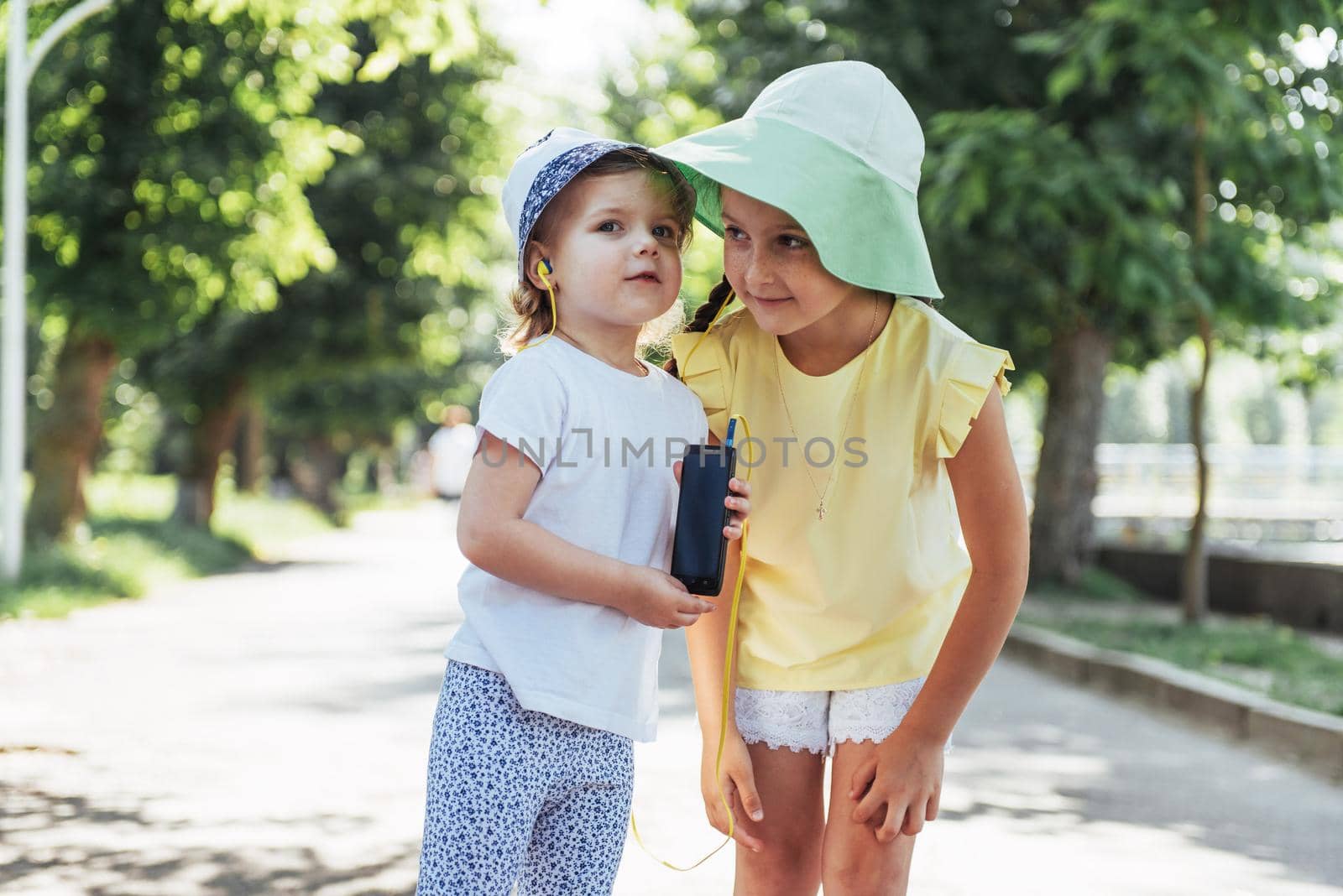 Happy girl with headphones to share music from your smartphone on street