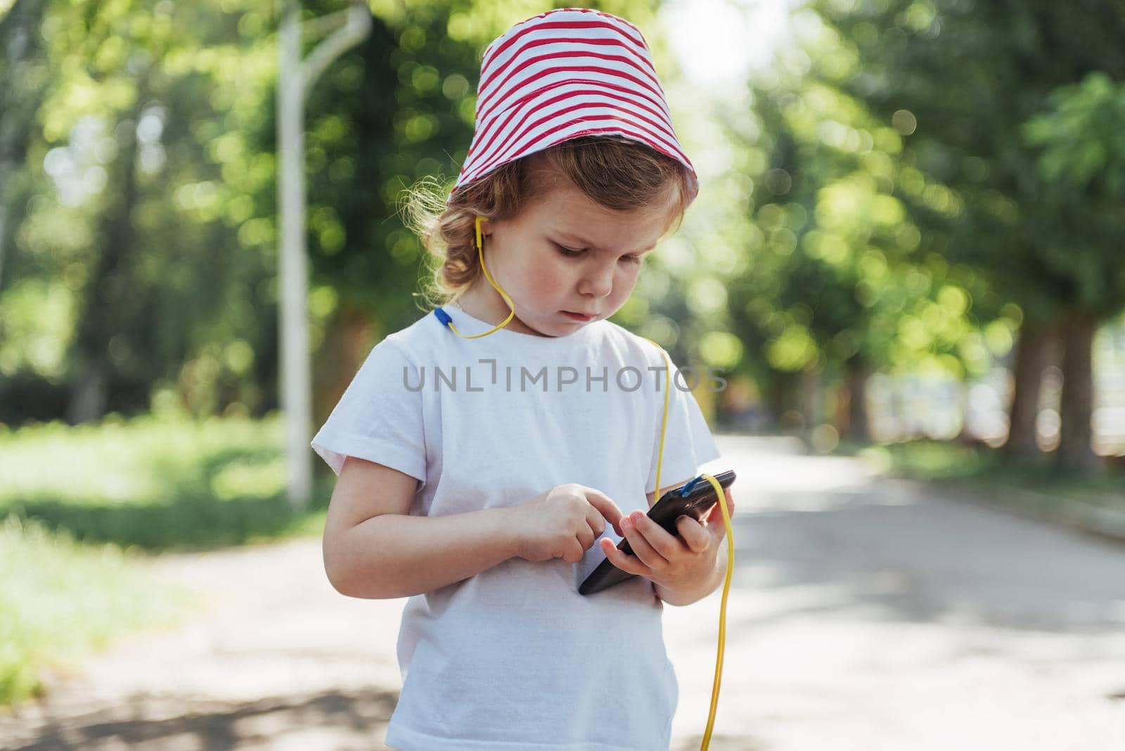 Cute girl listening to music with headphones outdoors.