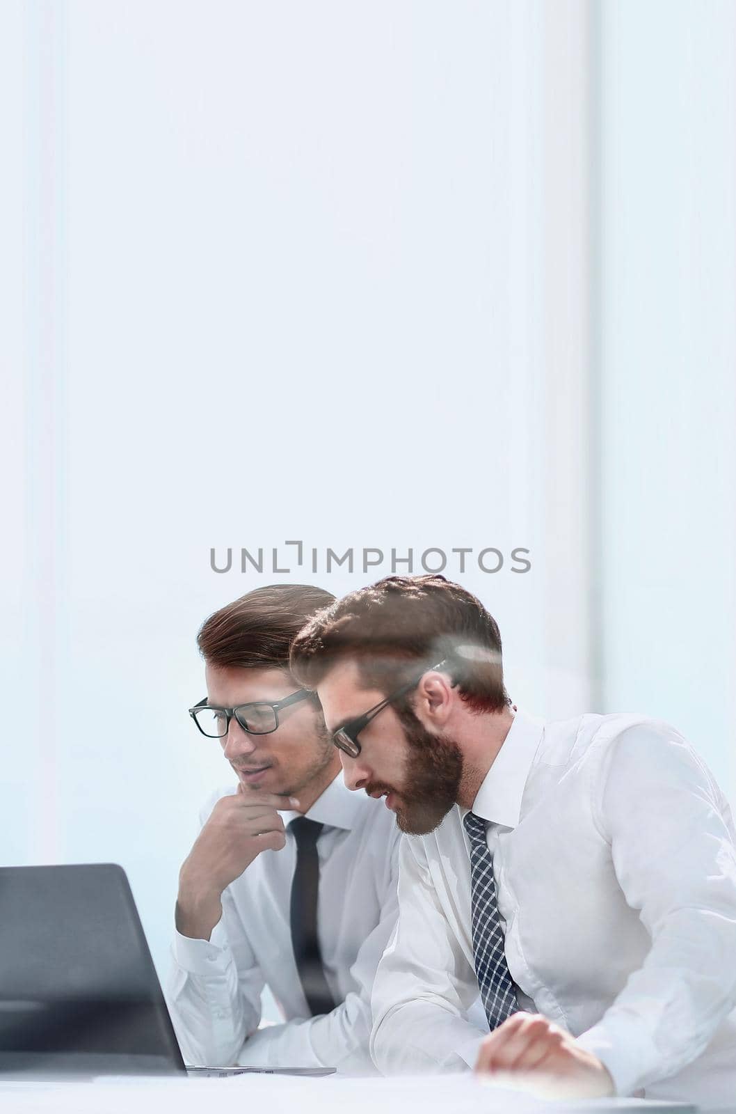 two business colleagues looking at the laptop screen . photo with copy space