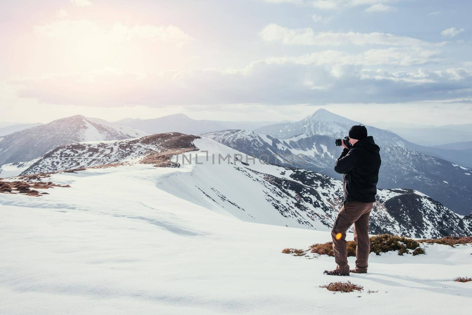 tourist looks at the landscape. Photographer on top of mountain. Spring landscape. Carpathians Ukraine Europe