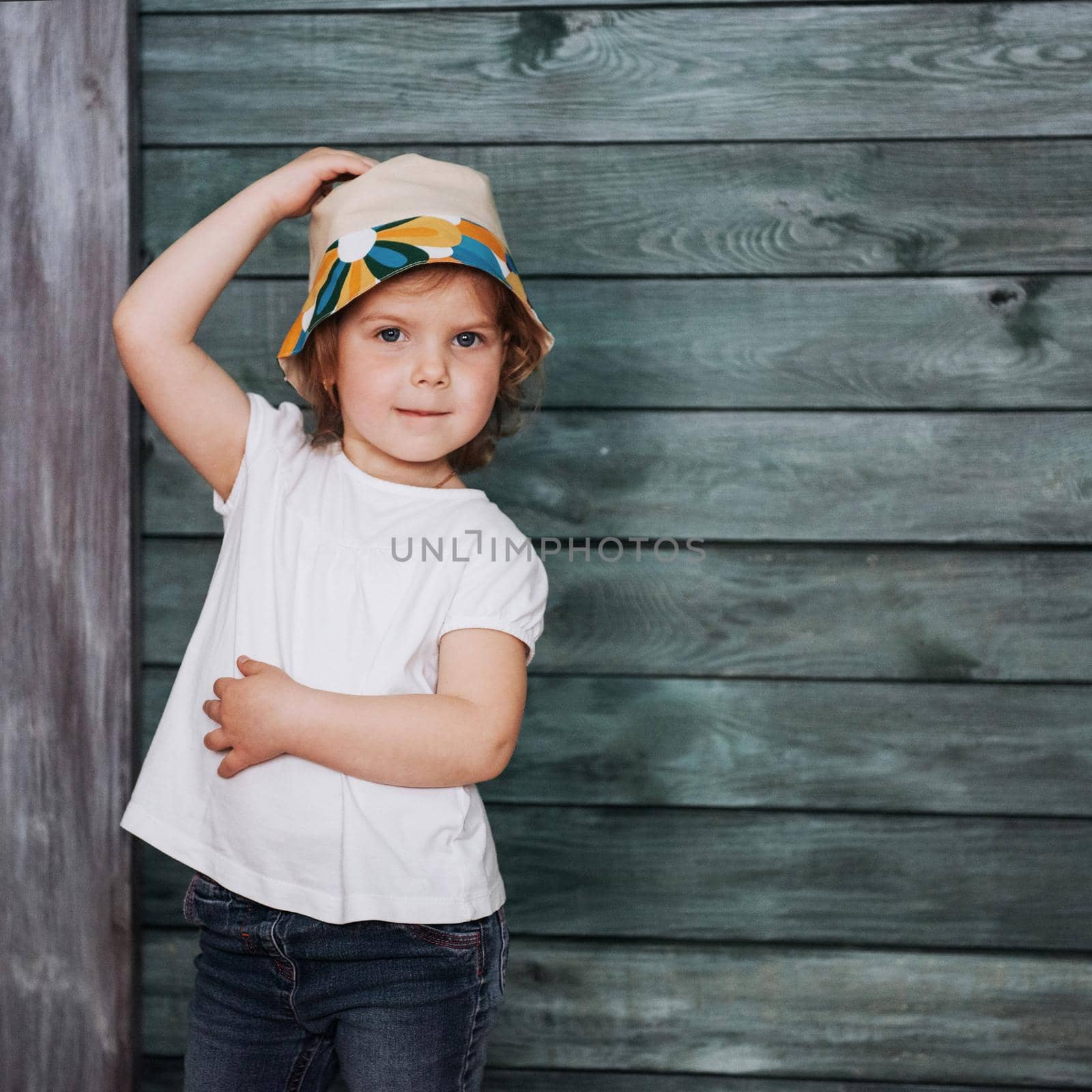 Stylish teenage girl leaning against a wall and looking at the camera