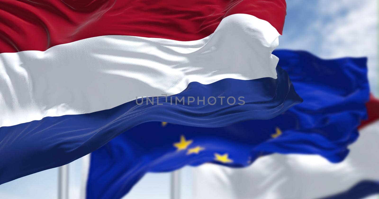 Detail of the national flag of the Netherlands waving in the wind with blurred european union flag in the background by rarrarorro