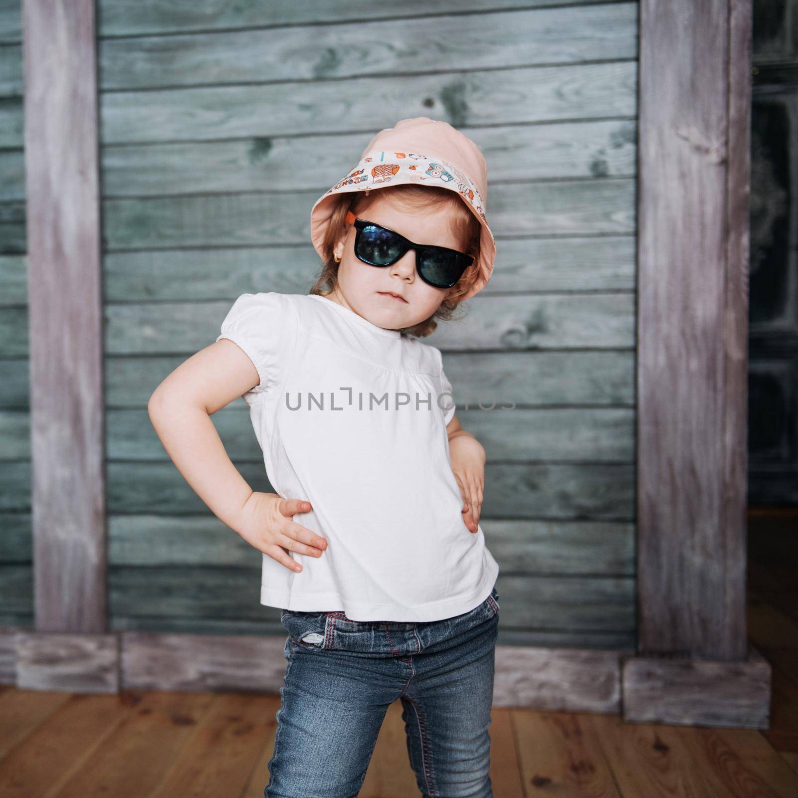Fashion little girl, a child dressed in the fashion and sunglasses. Posing for camera