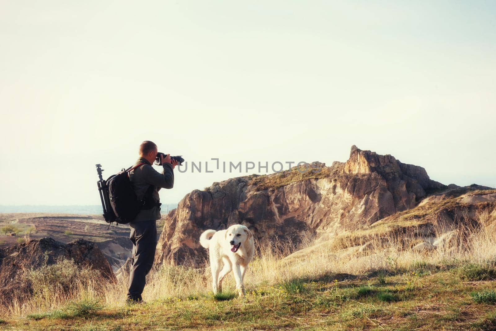 Photographer sandstone cliff and observing the natural landscape, Cappadocia, Turkey