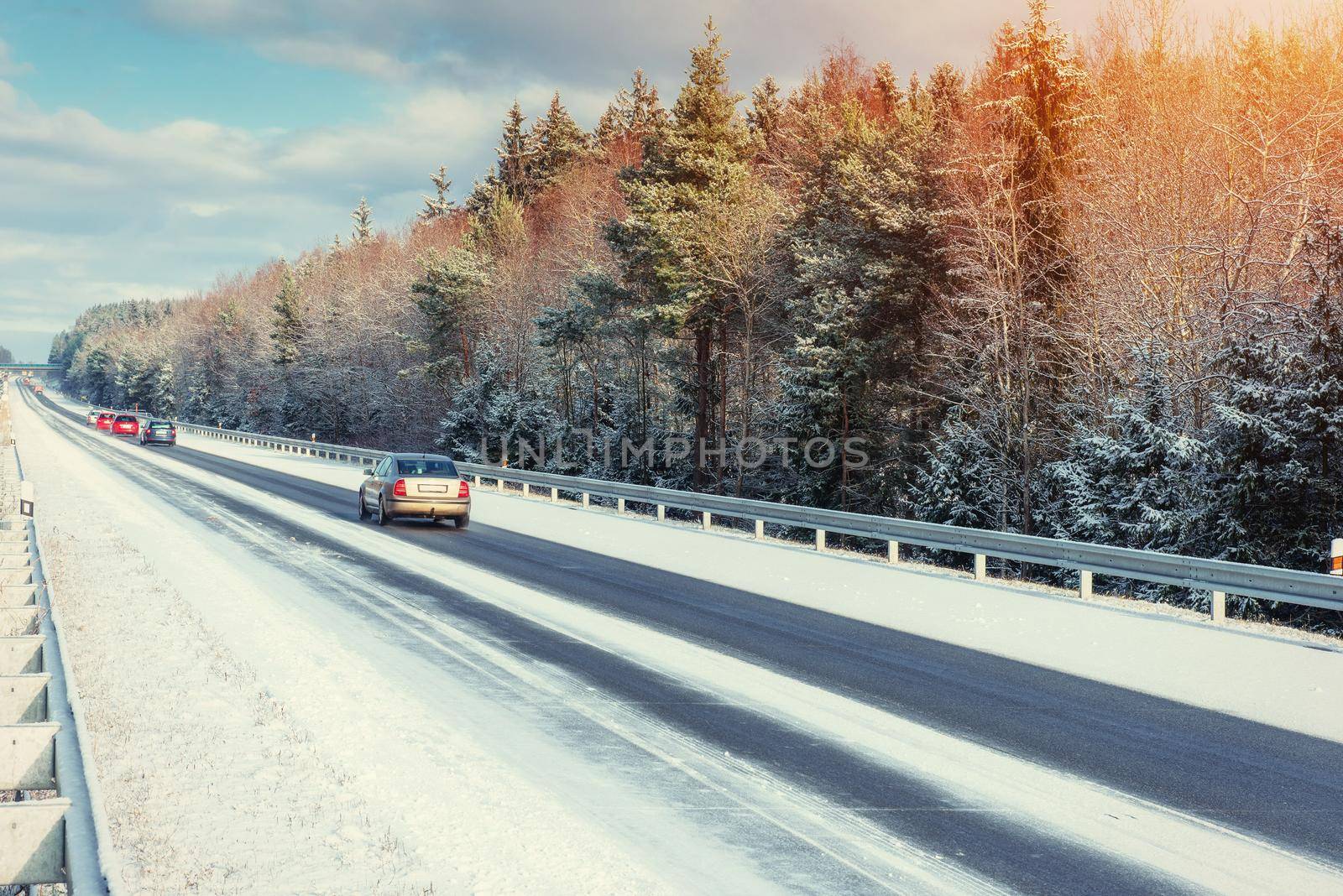 Winter road through snowy fields and forests.