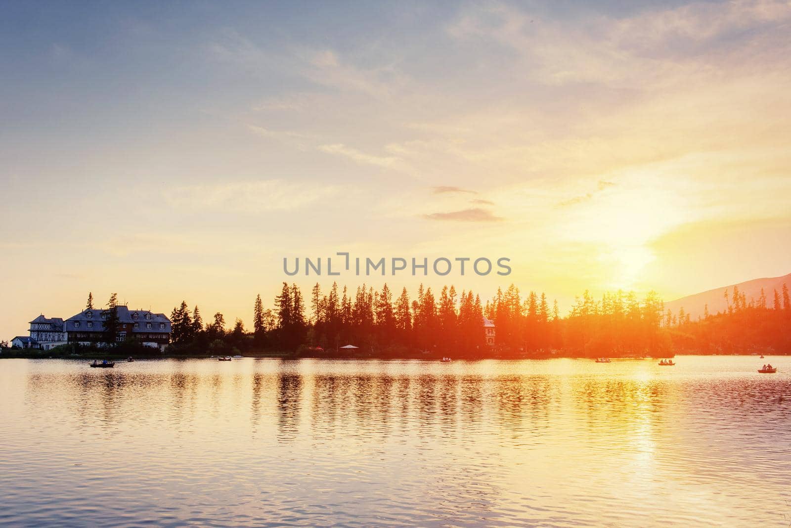 The sunrise over a lake in the park High Tatras. Shtrbske Pleso, Slovakia, Europe.