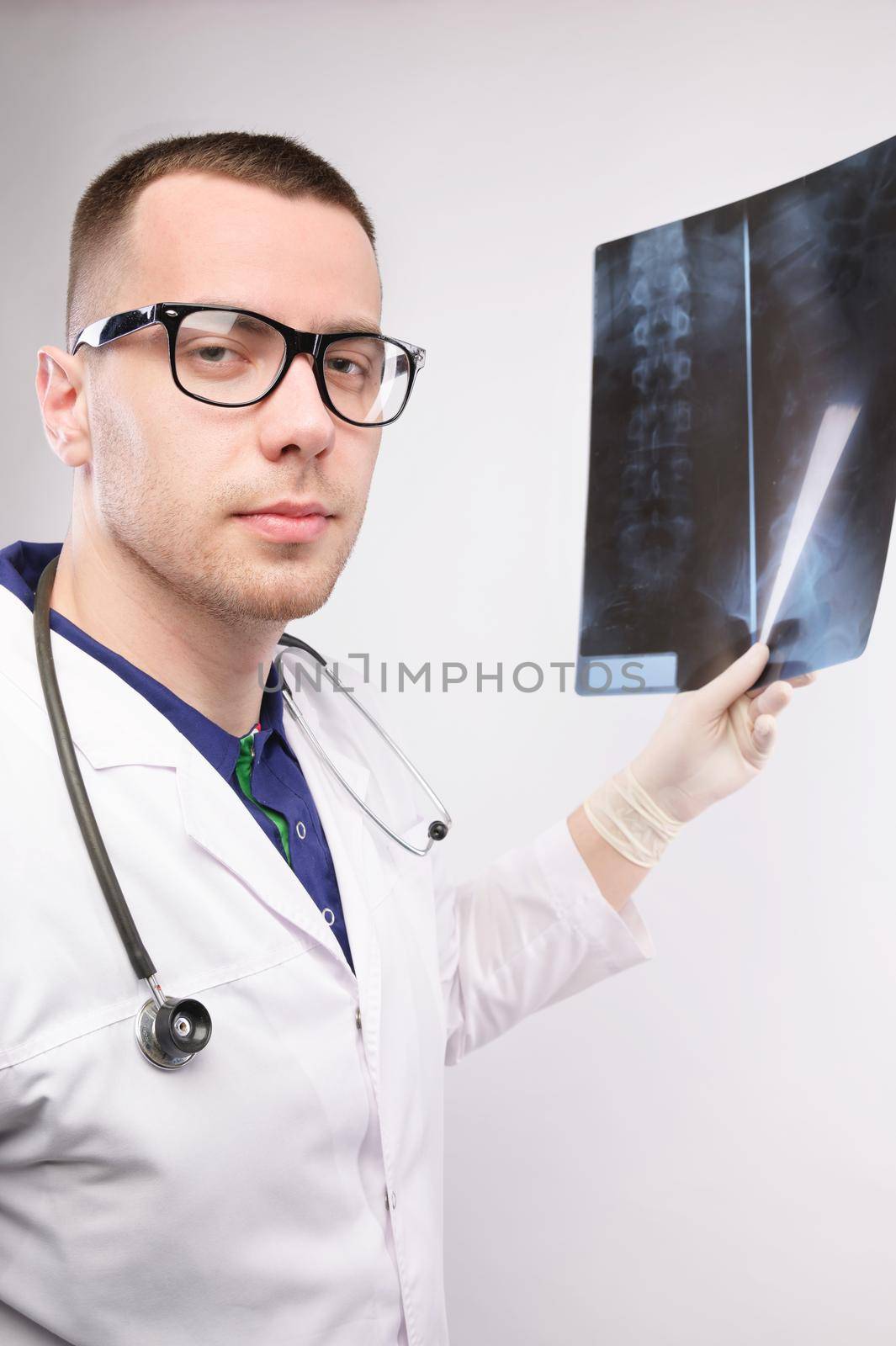 surgeon examines x-ray. spinal x-ray. health problems. nurse checking x-ray in hospital. An experienced male doctor interprets an x-ray. man looks. by yanik88