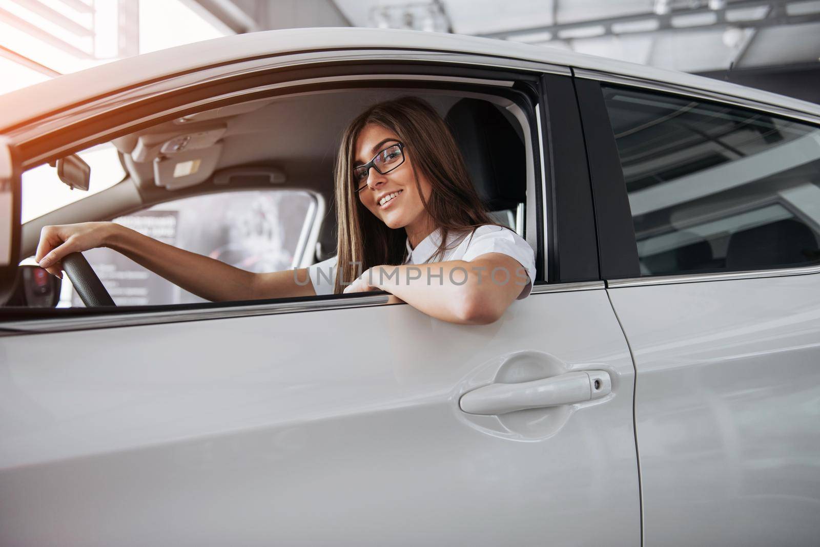 attractive young Caucasian woman looking at the camera from the front seat of the car