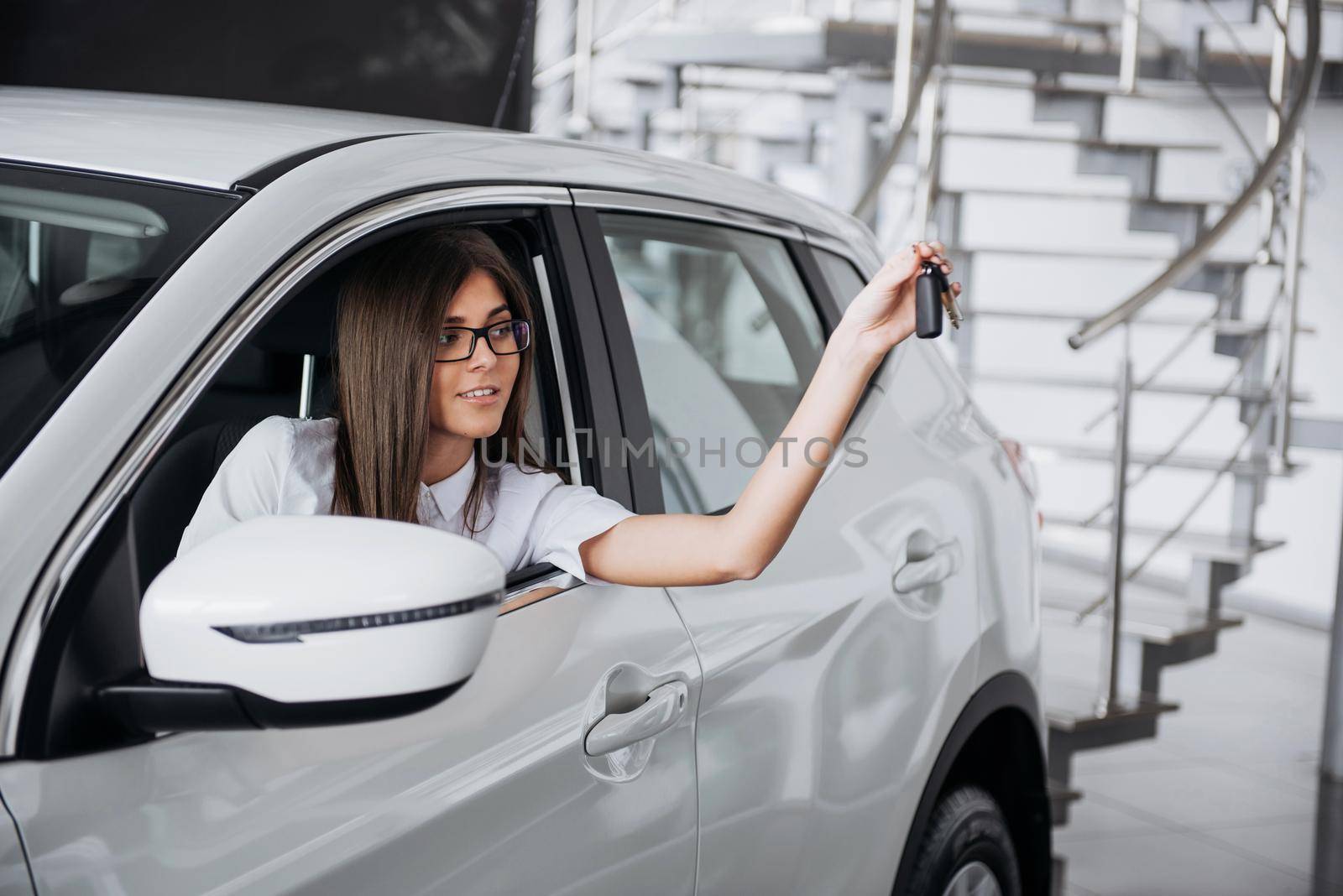 The woman driver smiling showing new car keys.