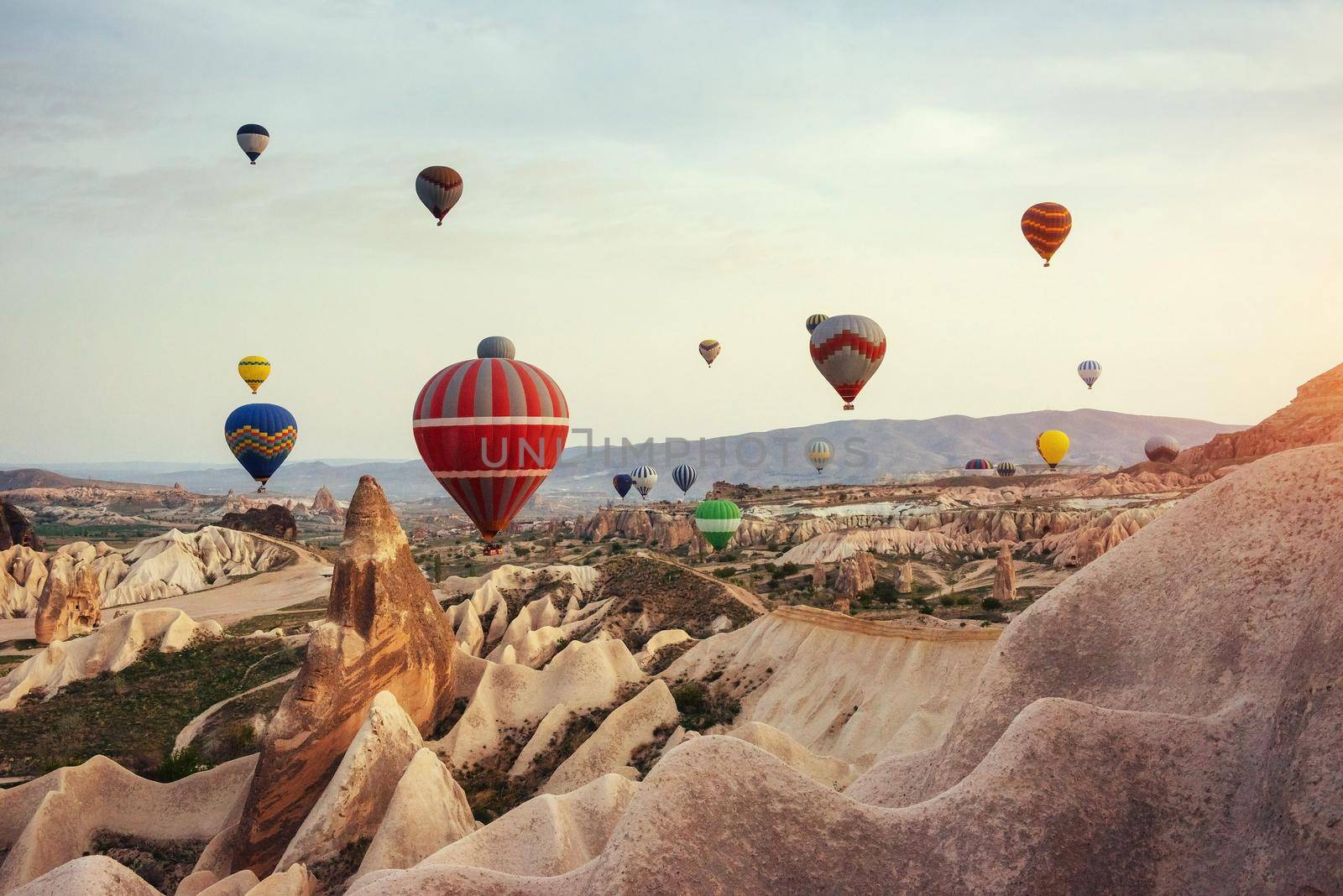 Hot air balloon flying over rock landscape at Cappadocia Turkey. Cappadocia with its valley, ravine, hills, located between the volcanic mountains in Goreme National Park.