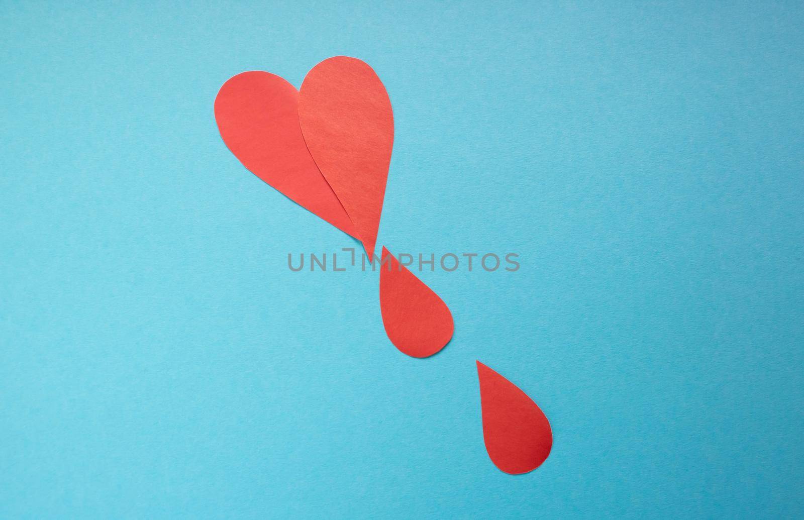 The concept of the World Blood Donor and Hemophilia Day. Red paper drops of blood on a blue background by lapushka62