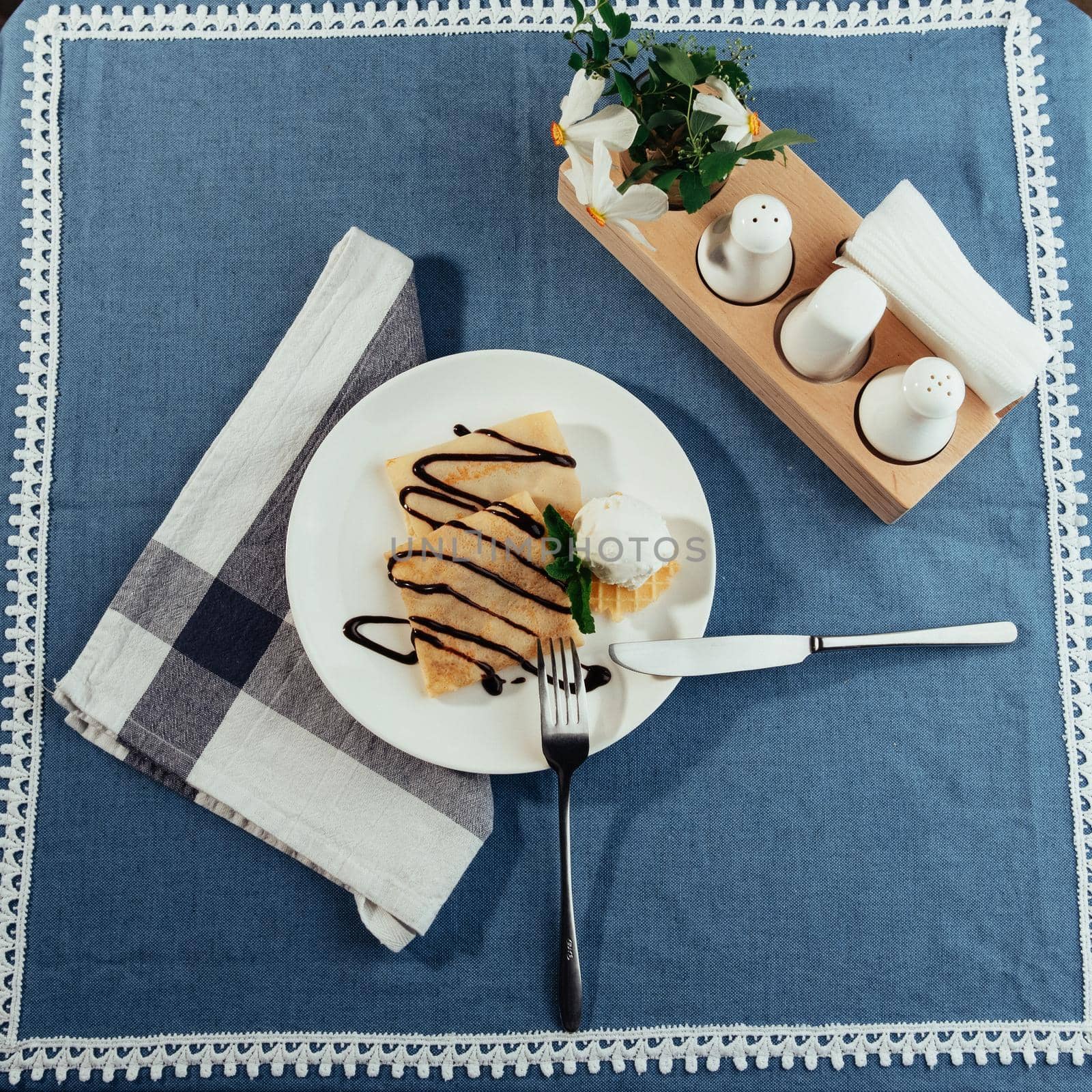 delicious pancakes with chocolate syrup and ice cream and a sprig of mint