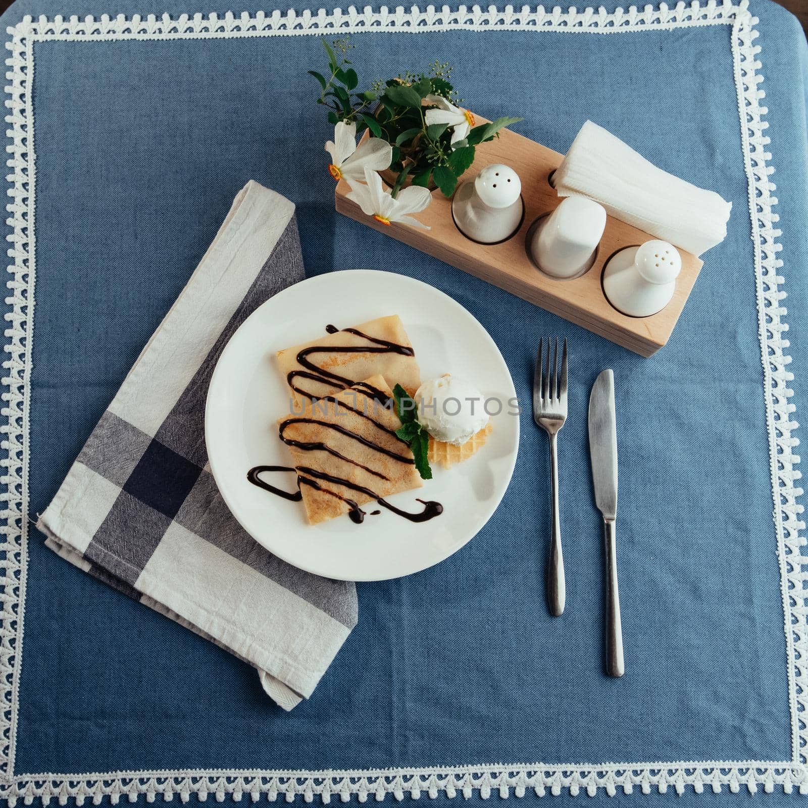 delicious pancakes with chocolate syrup and ice cream and a sprig of mint