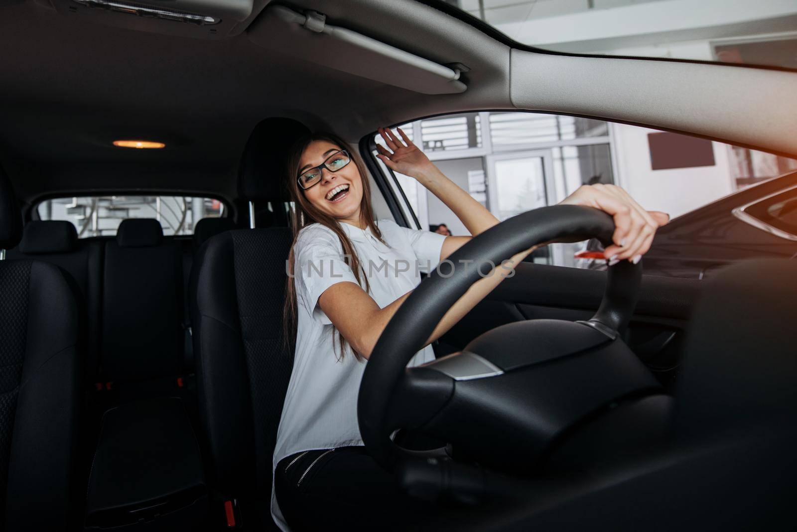 Pretty young woman driving her new car