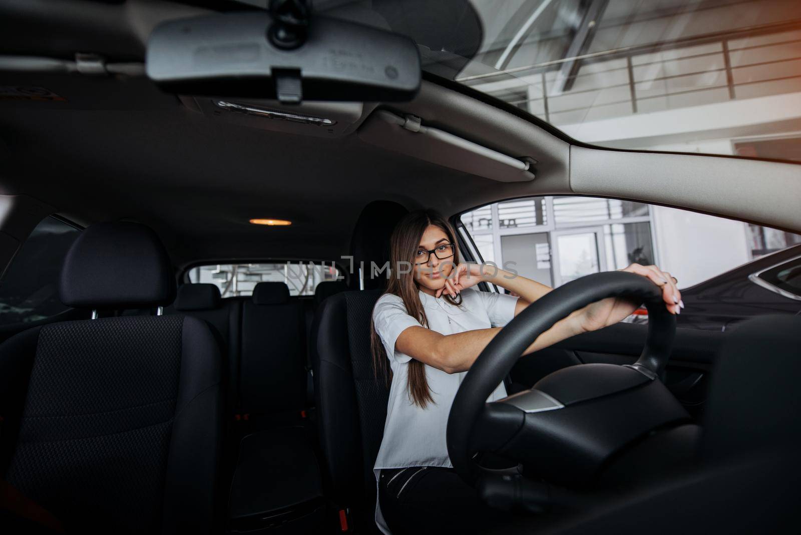 Pretty young woman driving her new car