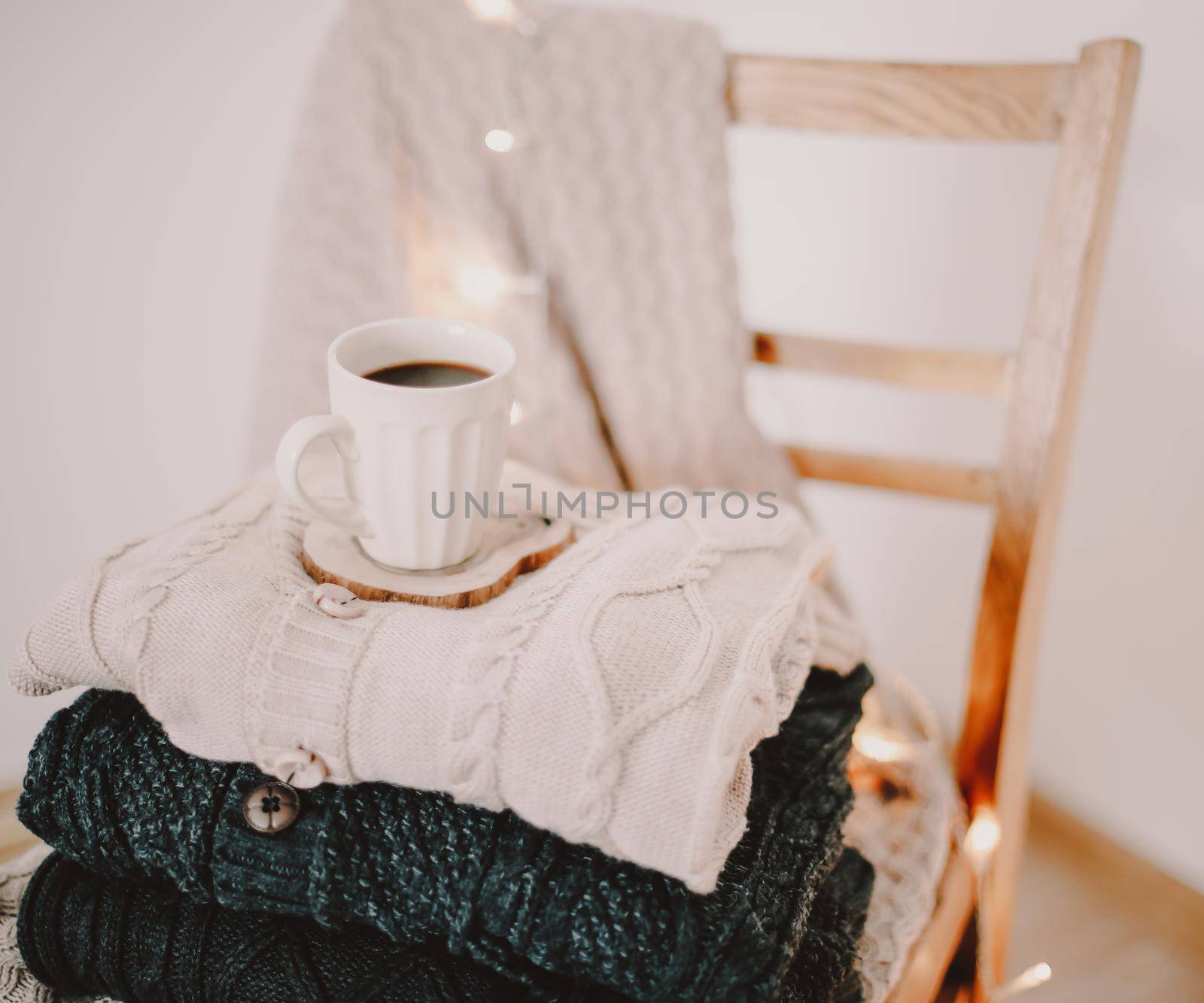 a cup of coffee on a knitted beige plaid