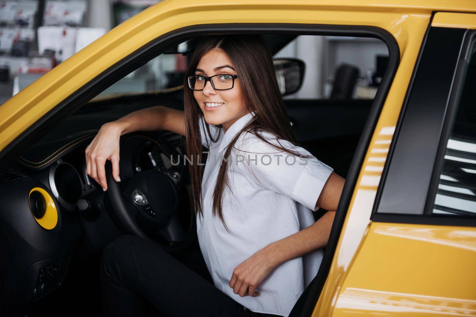 attractive young Caucasian woman looking at the camera from the front seat of the car