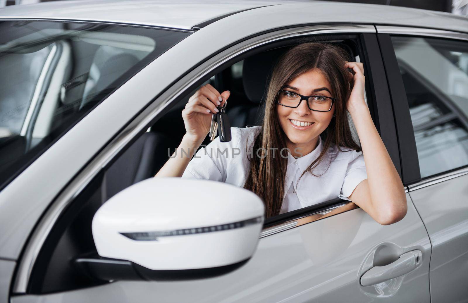 attractive young Caucasian woman looking at the camera from the front seat of the car