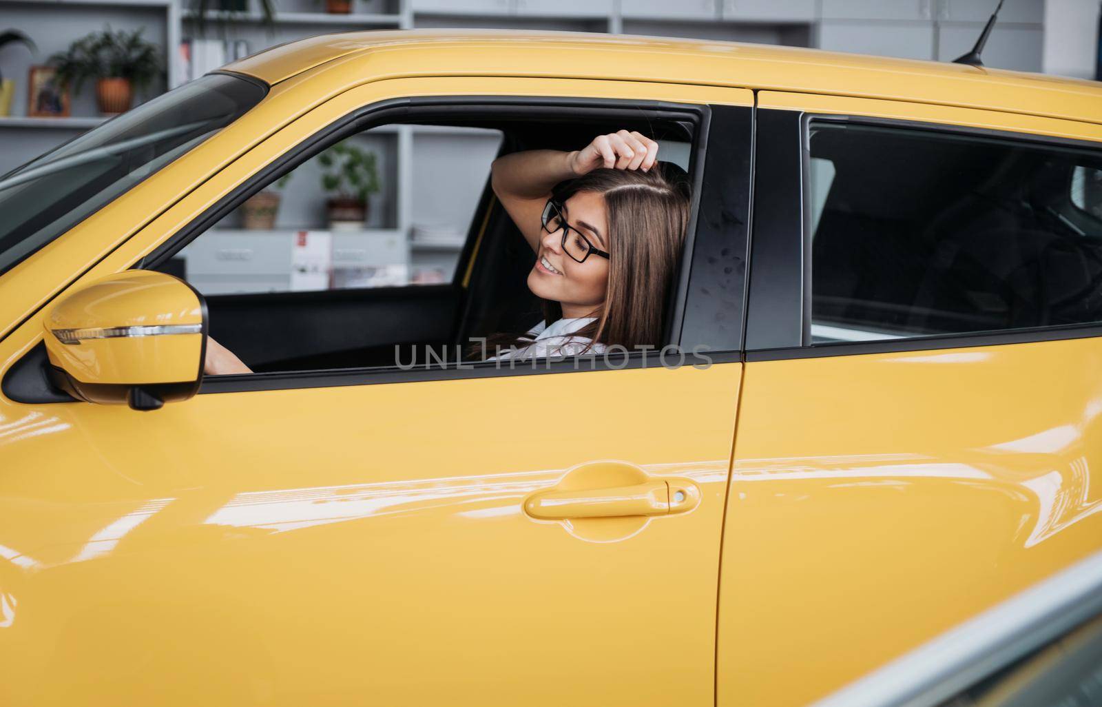 attractive young Caucasian woman looking at the camera from the front seat of the car