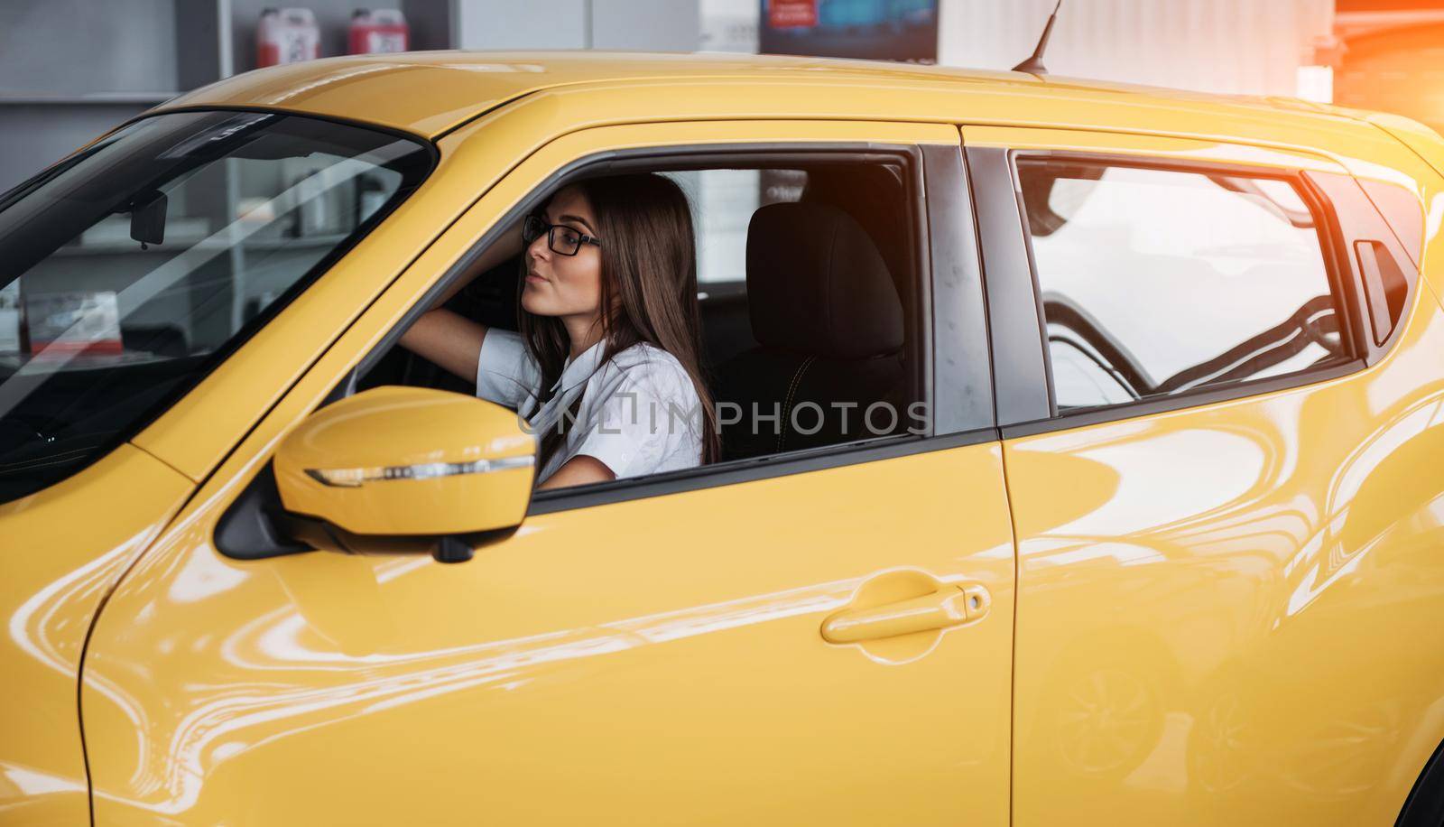 attractive young Caucasian woman looking at the camera from the front seat of the car