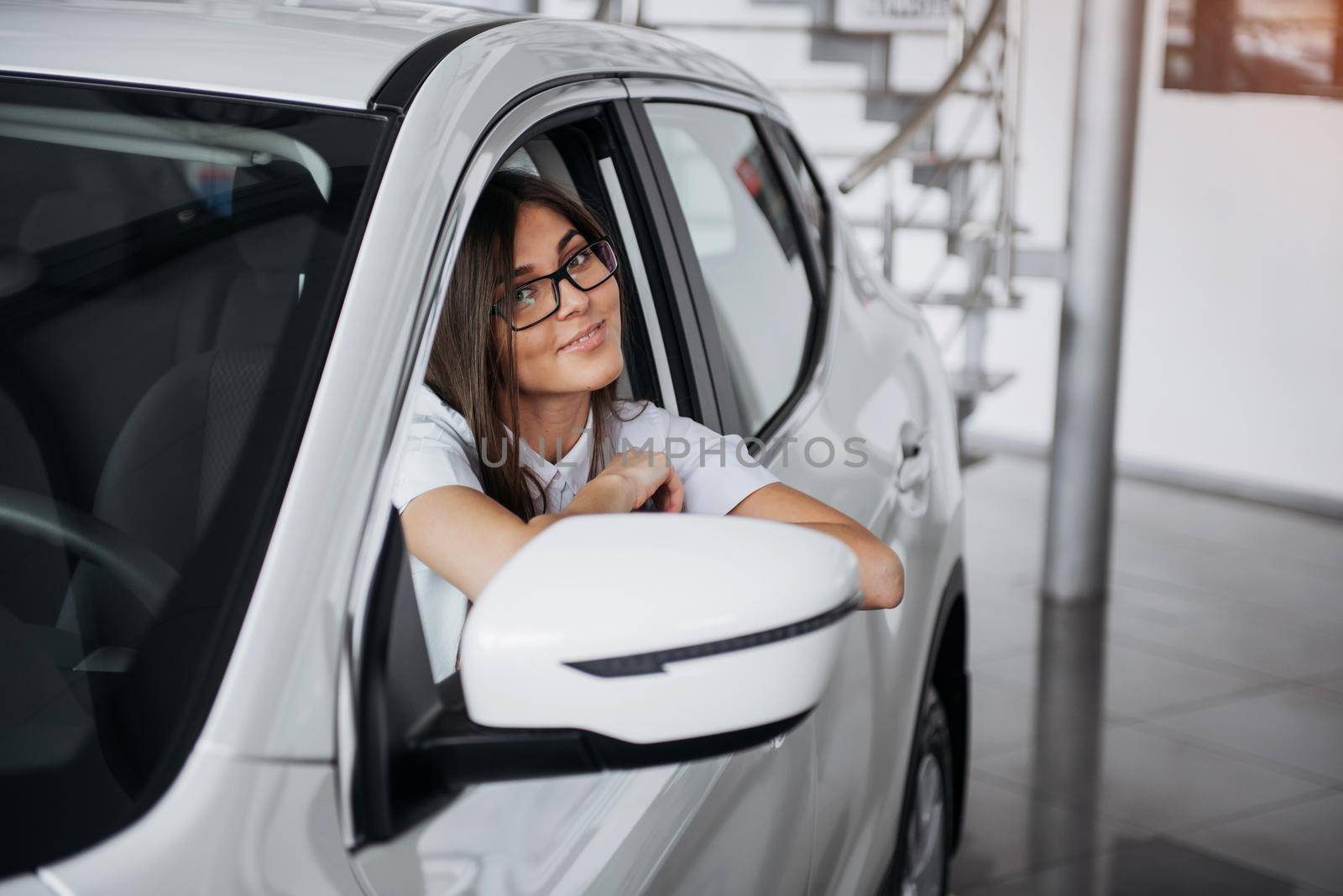attractive young Caucasian woman looking at the camera from the front seat of the car
