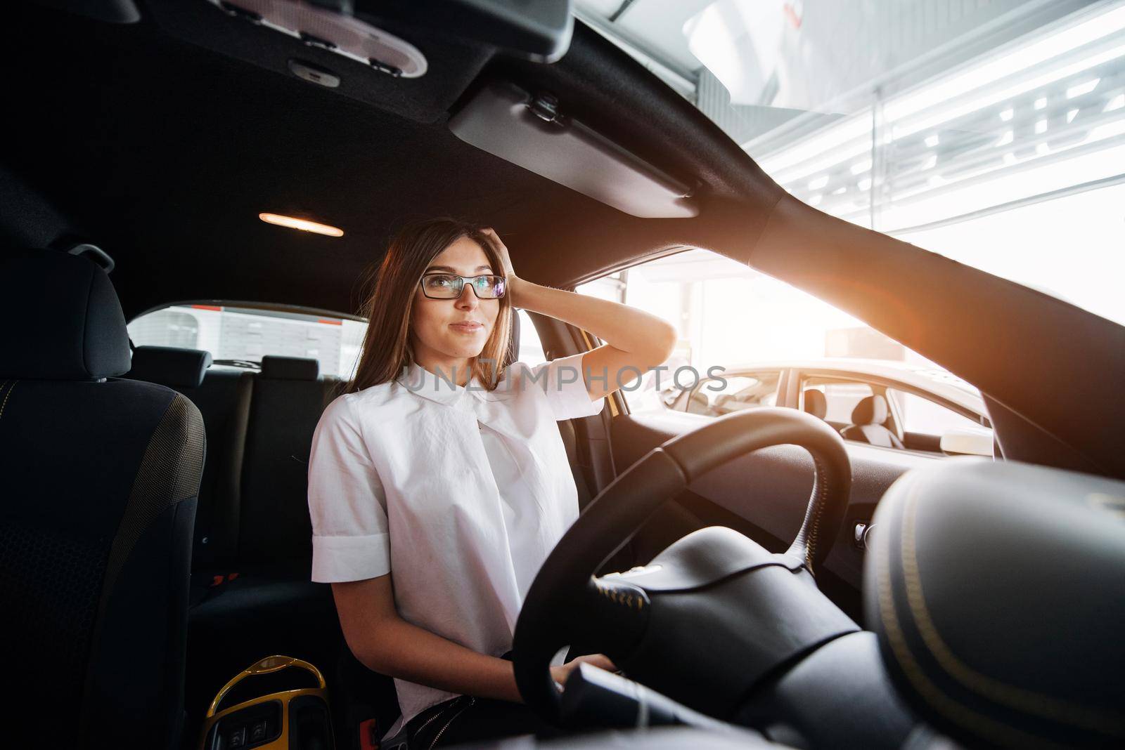 attractive young Caucasian woman looking at the camera from the front seat of the car