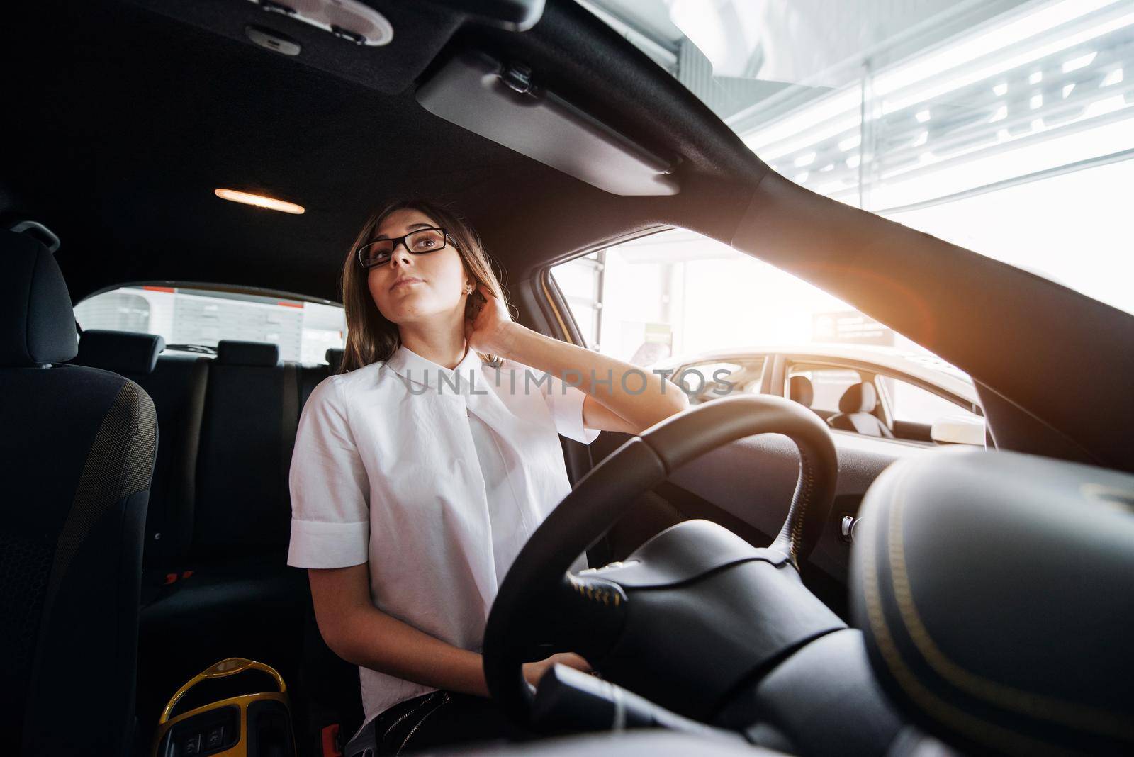 attractive young Caucasian woman looking at the camera from the front seat of the car