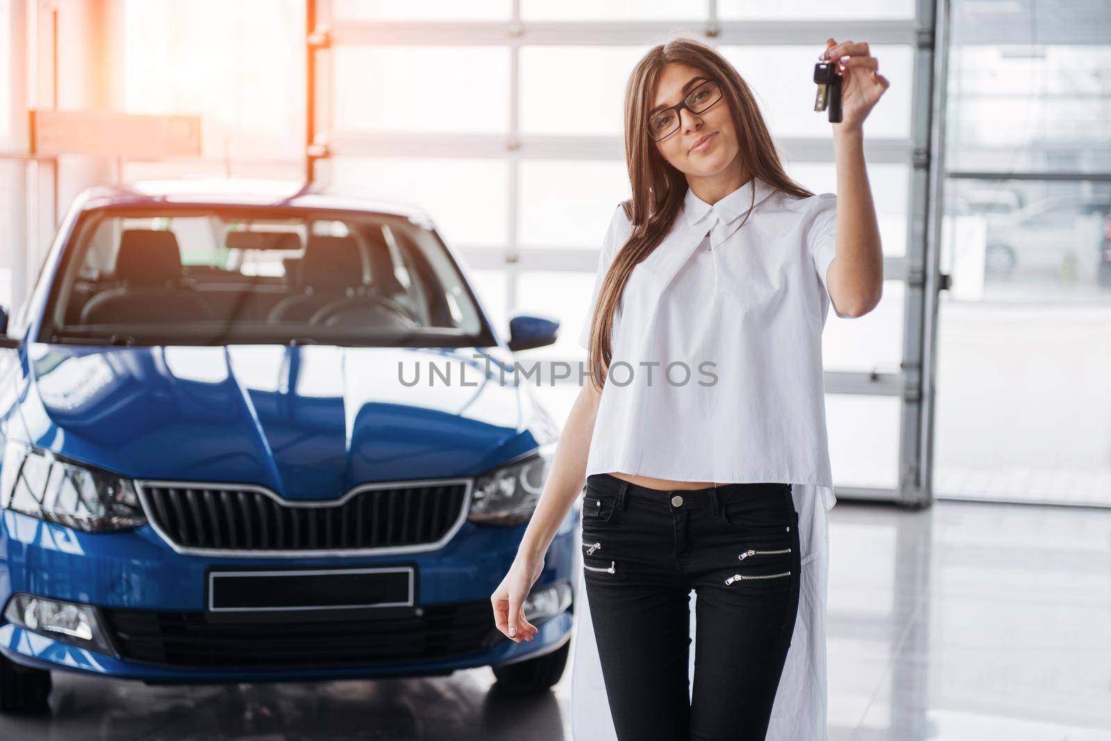 Young happy woman near the car with keys in hand - concept of buying car
