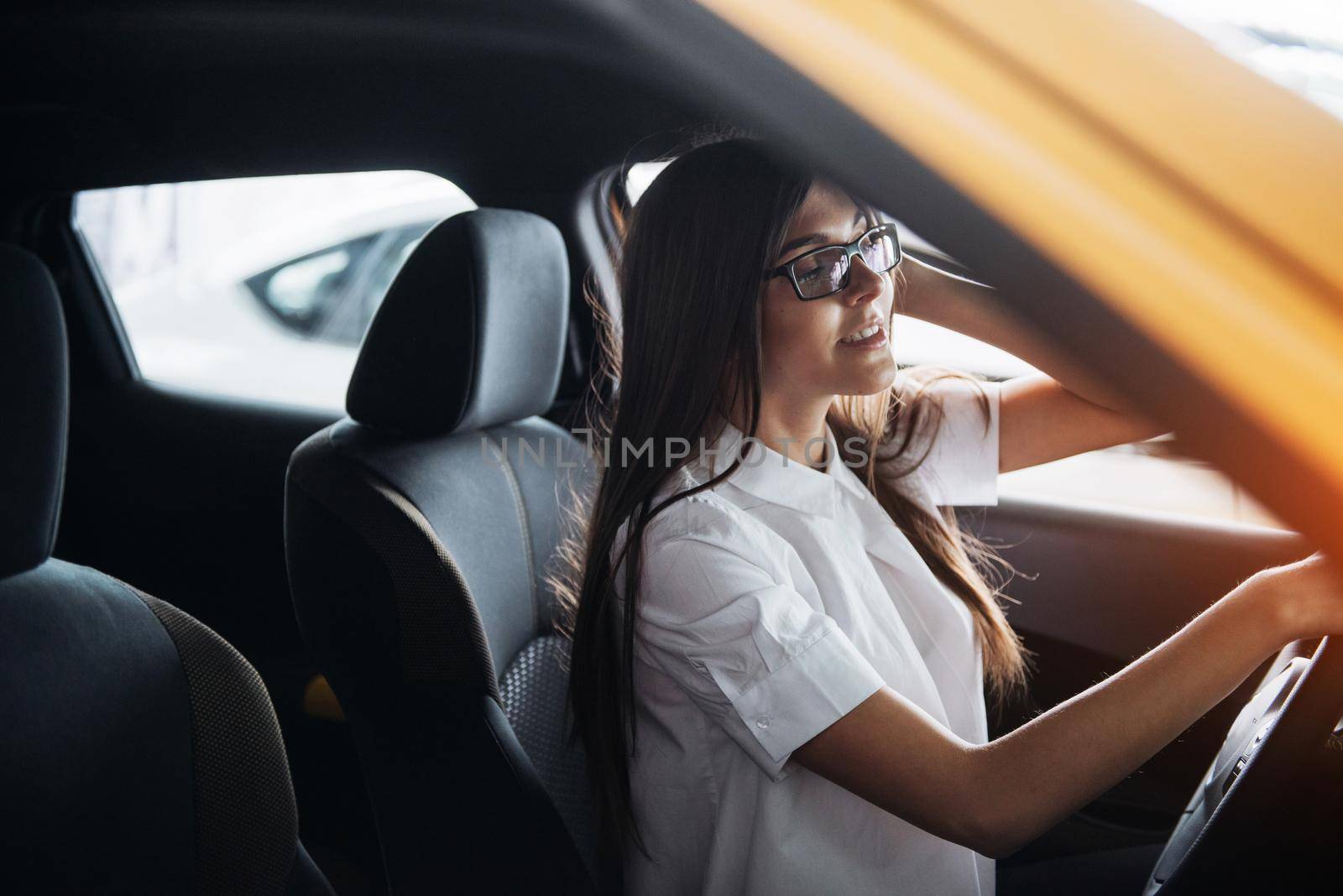 attractive young Caucasian woman looking at the camera from the front seat of the car