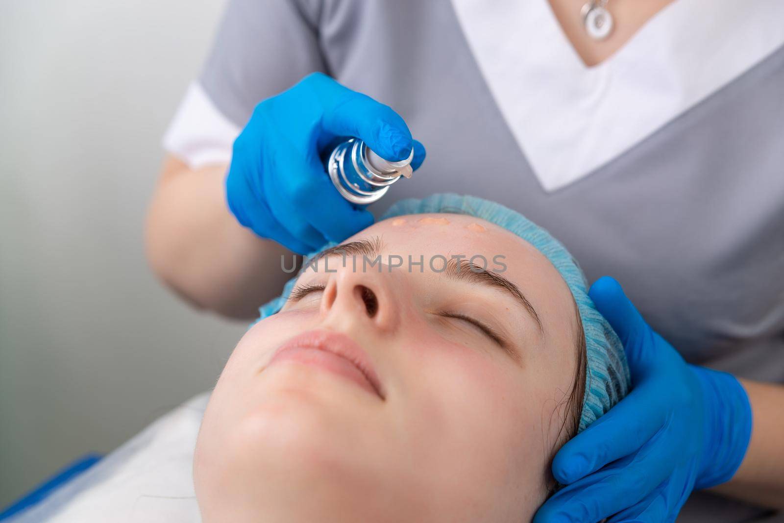 Face skin cream treatment or therapy for tired face skin. Dermatologist applying cream on female face skin.