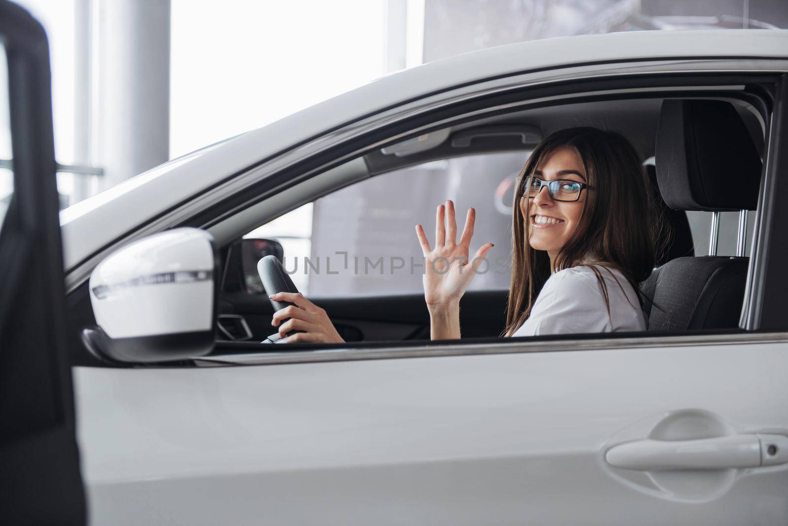 attractive young Caucasian woman looking at the camera from the front seat of the car