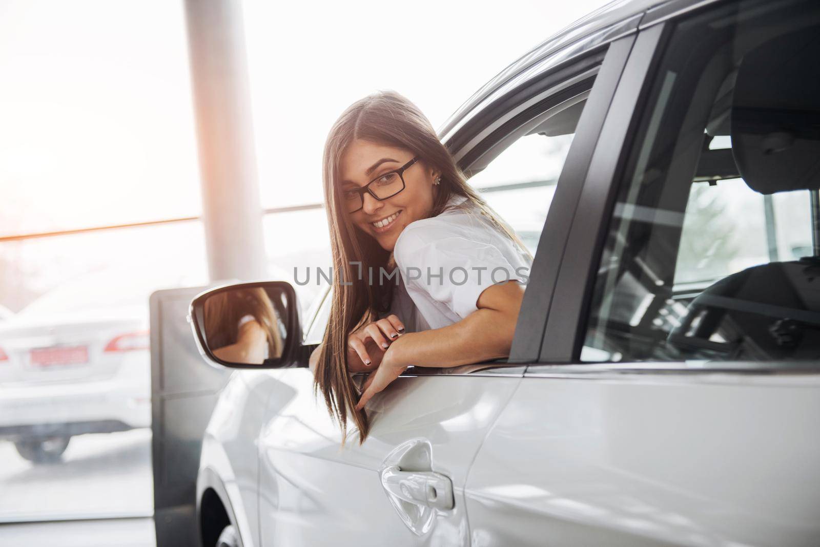 Pretty young woman driving her new car