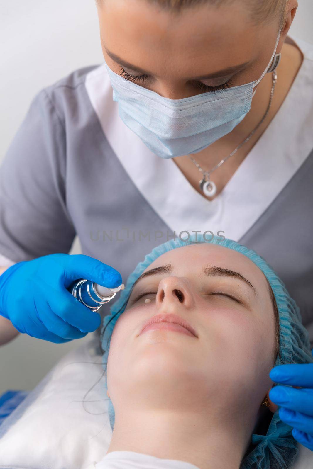 Face skin cream treatment or therapy for tired face skin. Dermatologist applying cream on female face skin.