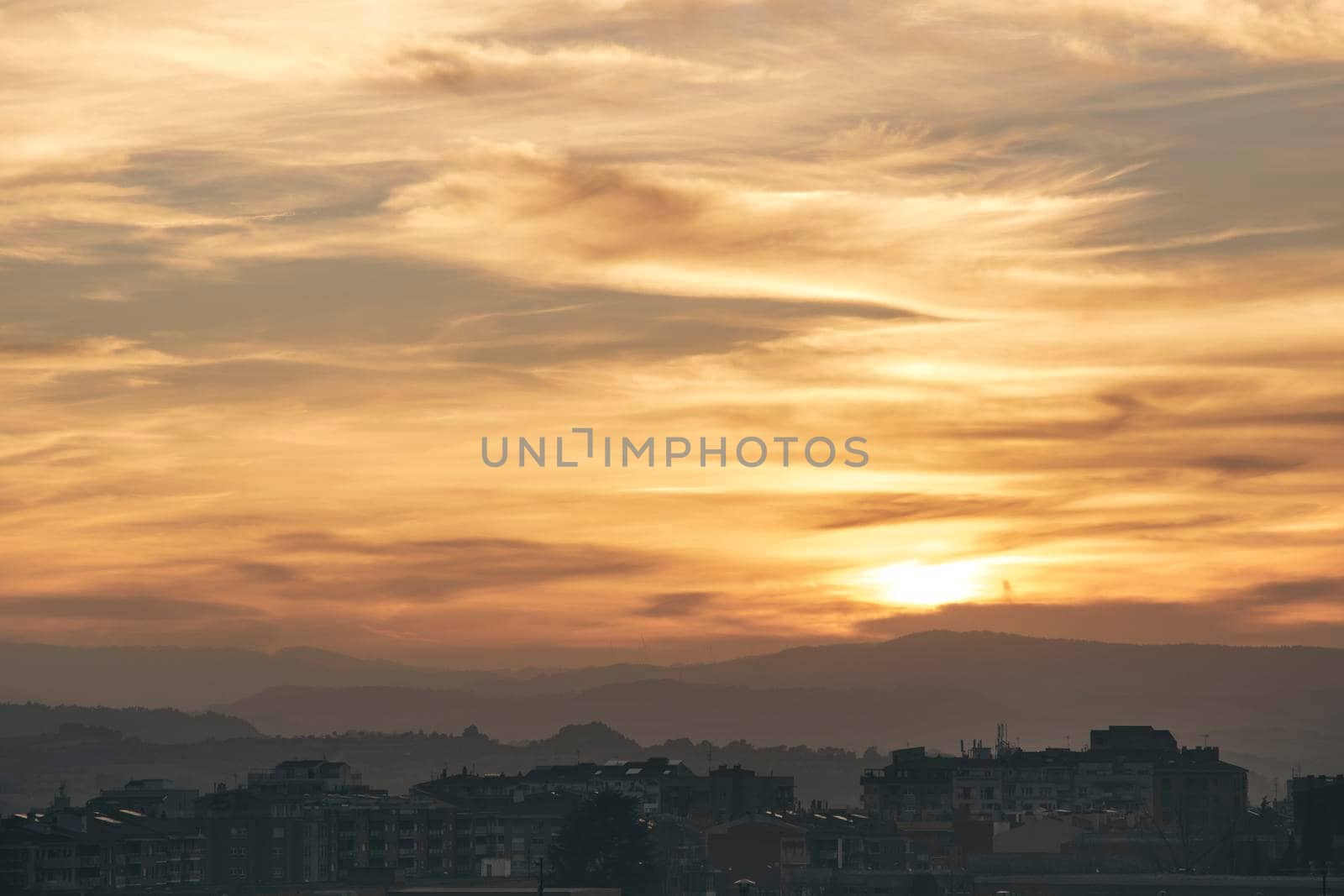 Beautiful sunset view of Igualada city under a cloudy sky and some mountains in the background
